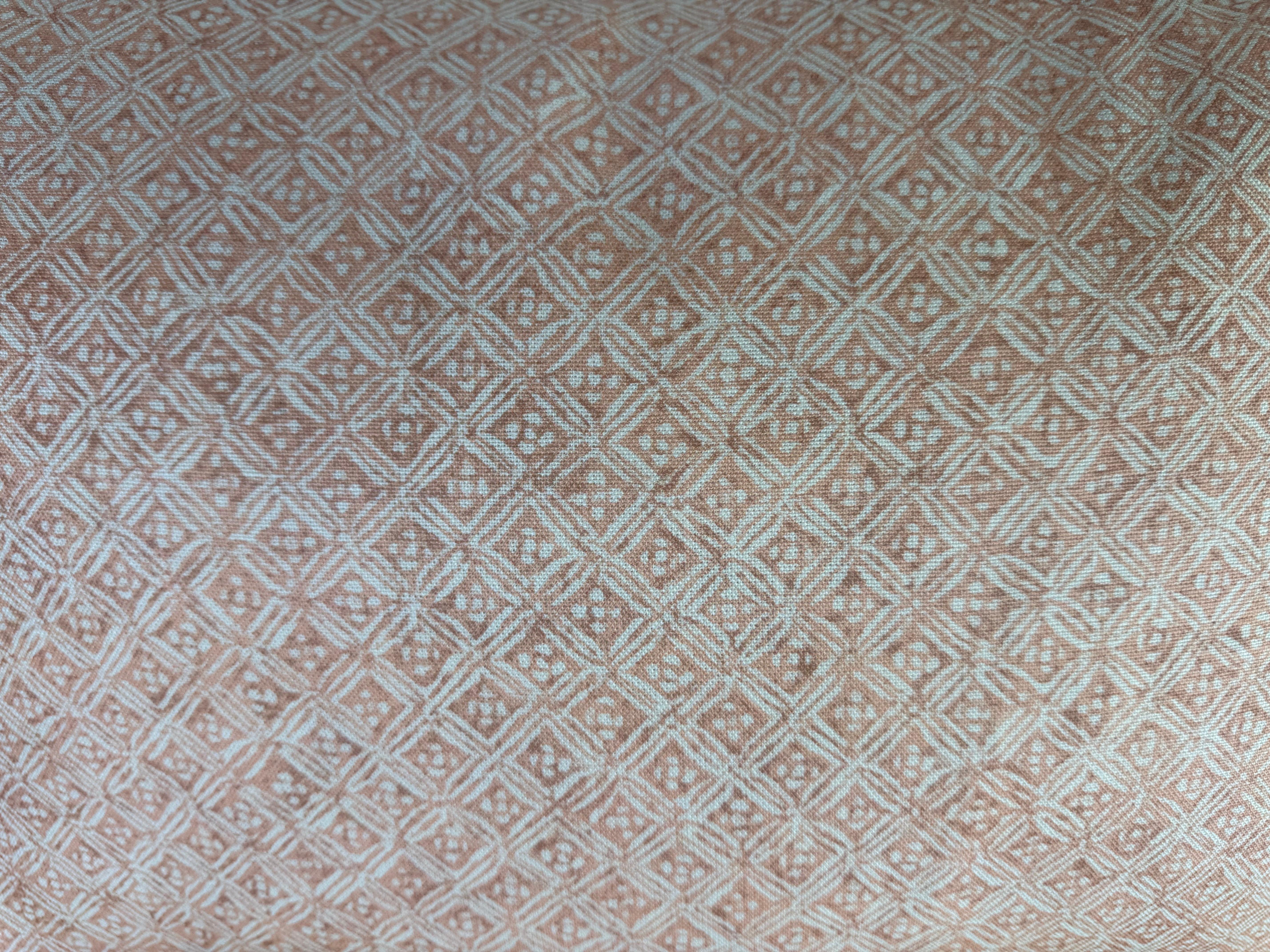 Una coppia di cuscini decorativi realizzati in un tessuto di lino finemente stampato con un motivo geometrico a rombi in terracotta e avorio. Il motivo sottile e strutturato conferisce calore e raffinatezza, mentre il retro in lino naturale offre