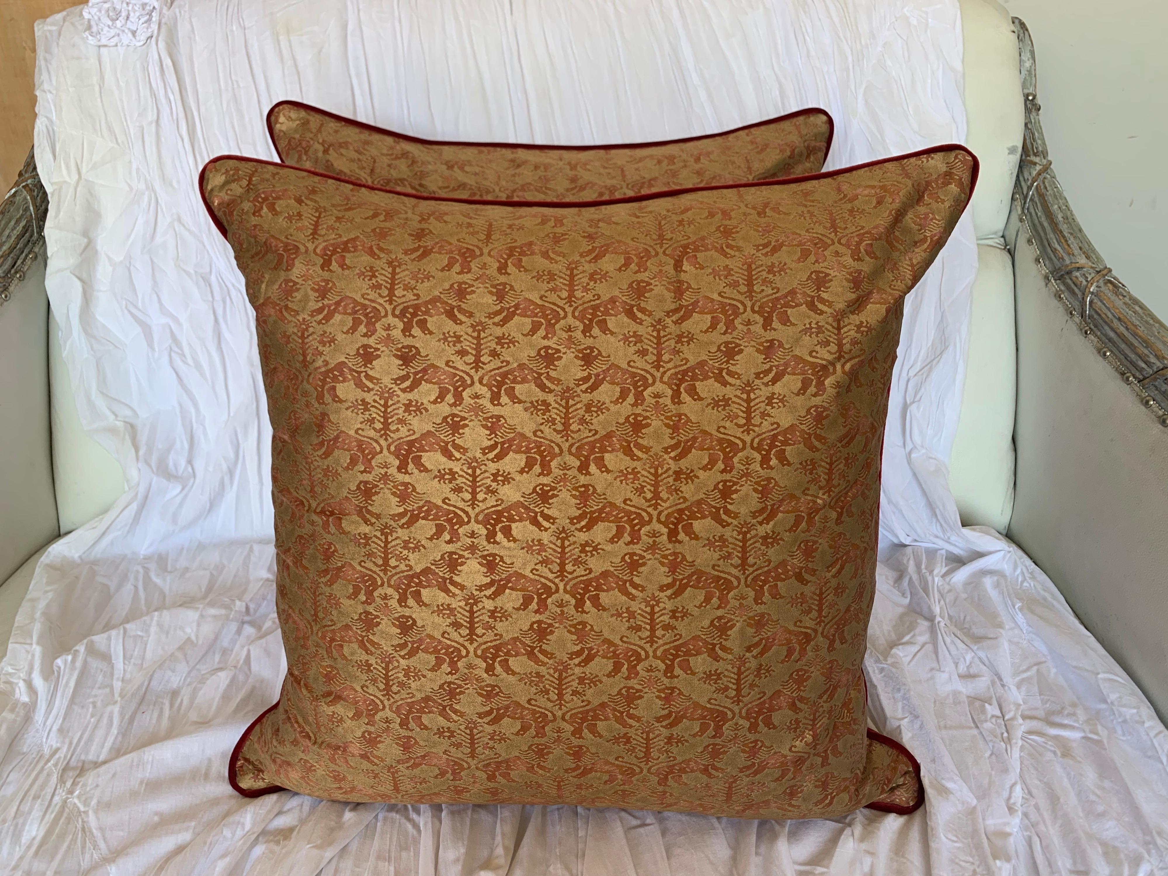 Pair of custom Richelieu patterned Fortuny pillows depicting Venetian lions in red & gold. The backs are velvet and the pillows are finished with a self cording. Down inserts, sewn closed.