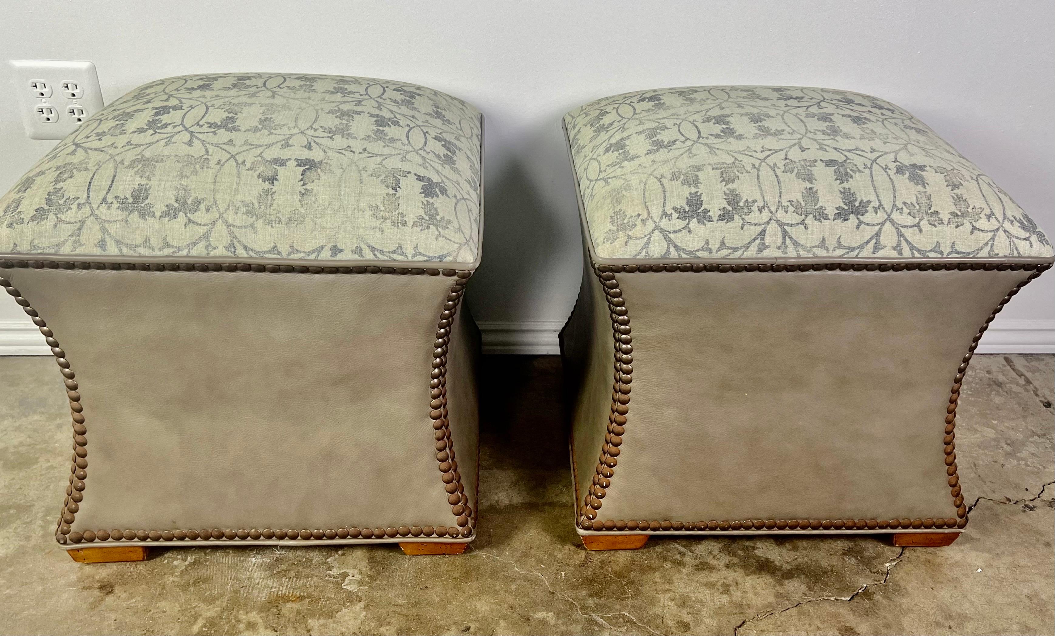 Pair of custom ottomans made with authentic Rose Tarlow fabric tops and neutral latte colored leather bases with nailhead trim detail.