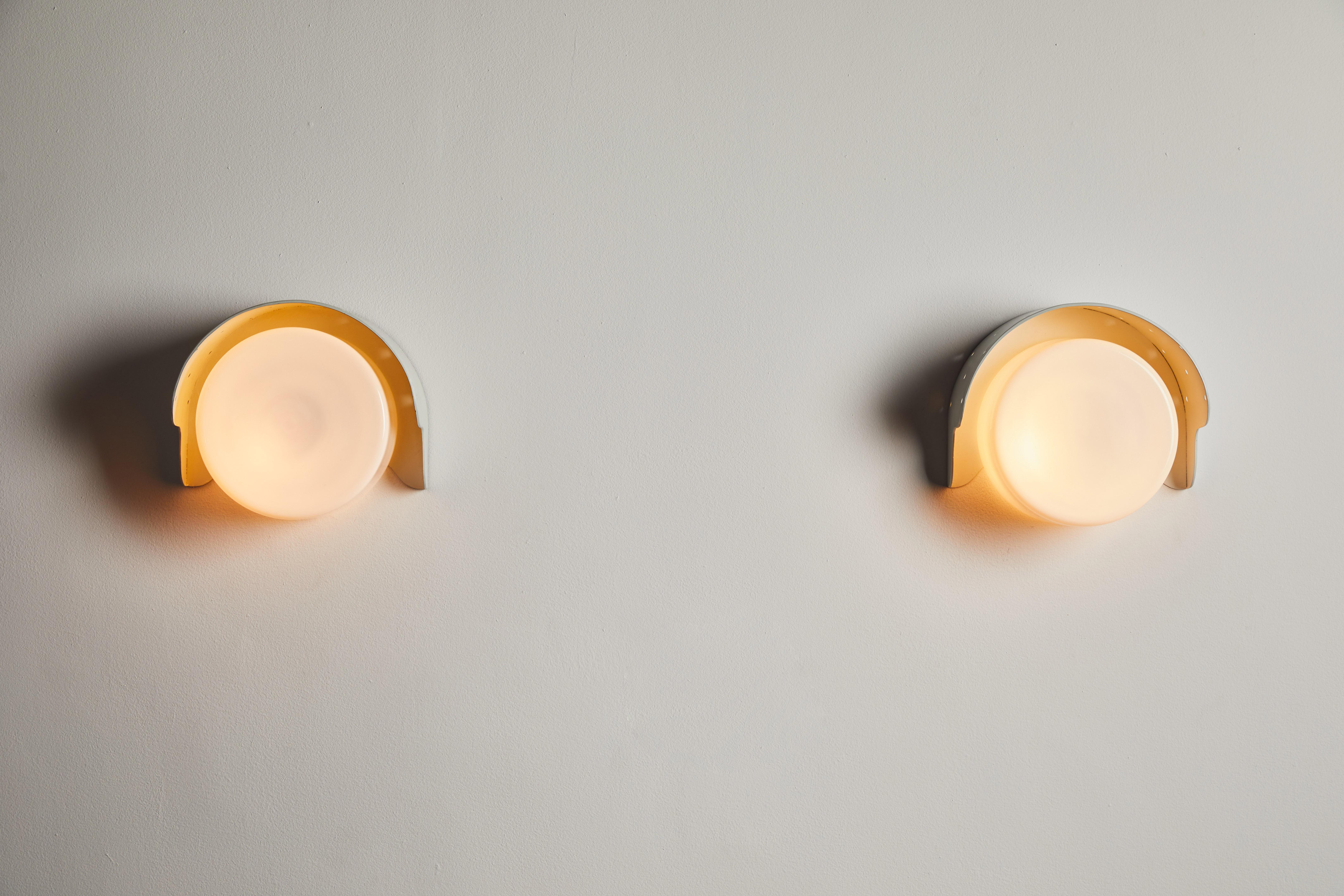 Pair of custom sconces by Paavo Tynell. Designed and manufactured in Finland, circa 1950s. Lacquered metal and glass. Rewired for U.S. standards. We recommend one E27 100w maximum bulb per sconce. Bulbs provided as a one time courtesy. Retains