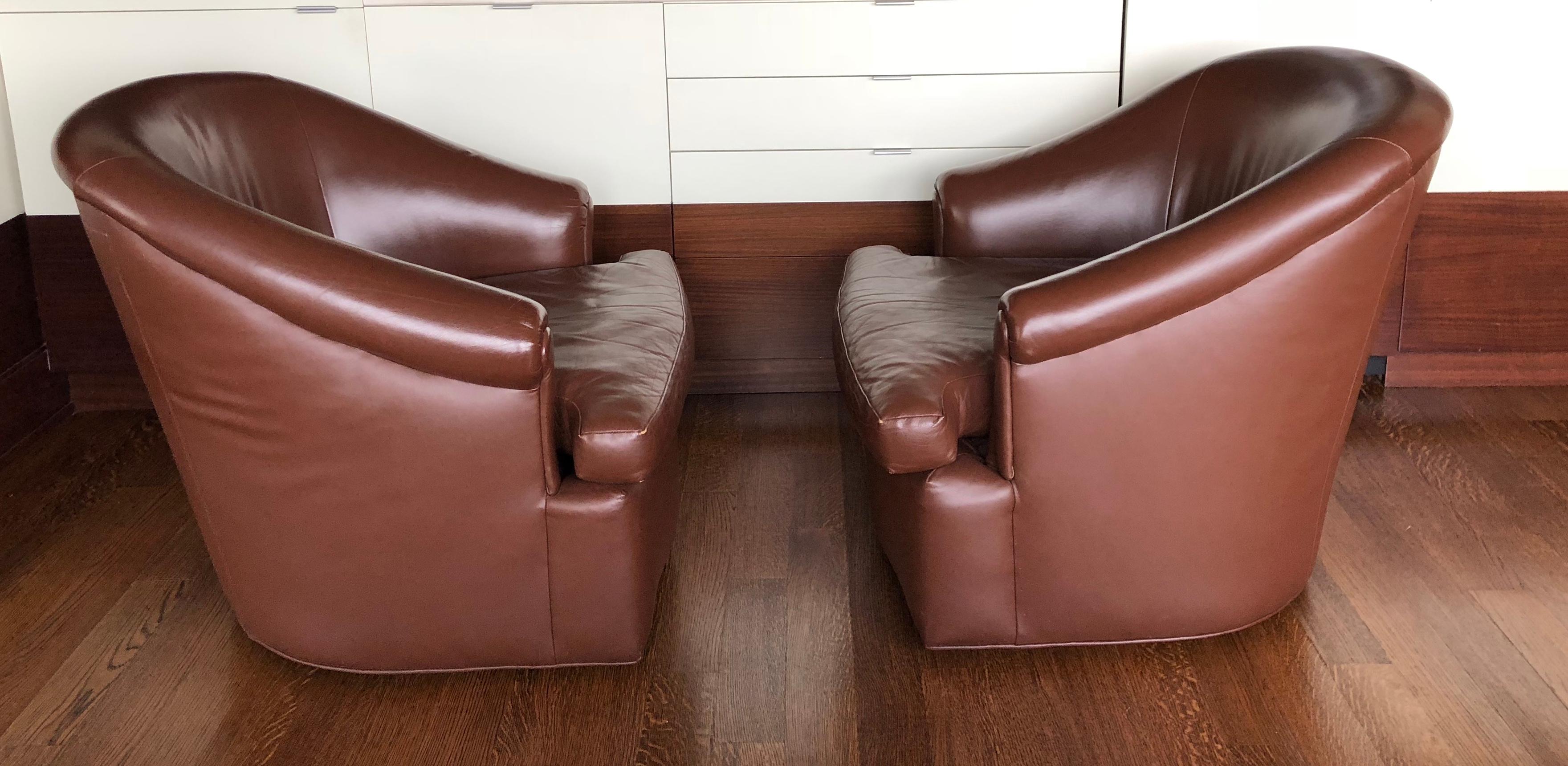 Pair of custom swivel club chairs in rich brown leather.