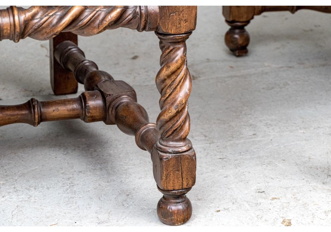 Une paire de grands fauteuils dramatiques de style jacobéen dans un remarquable traitement de tissu sur mesure. Chacune repose sur des pieds en forme de boule sculptée, des pieds en torsion d'orge et un brancard avant avec des supports de brancard