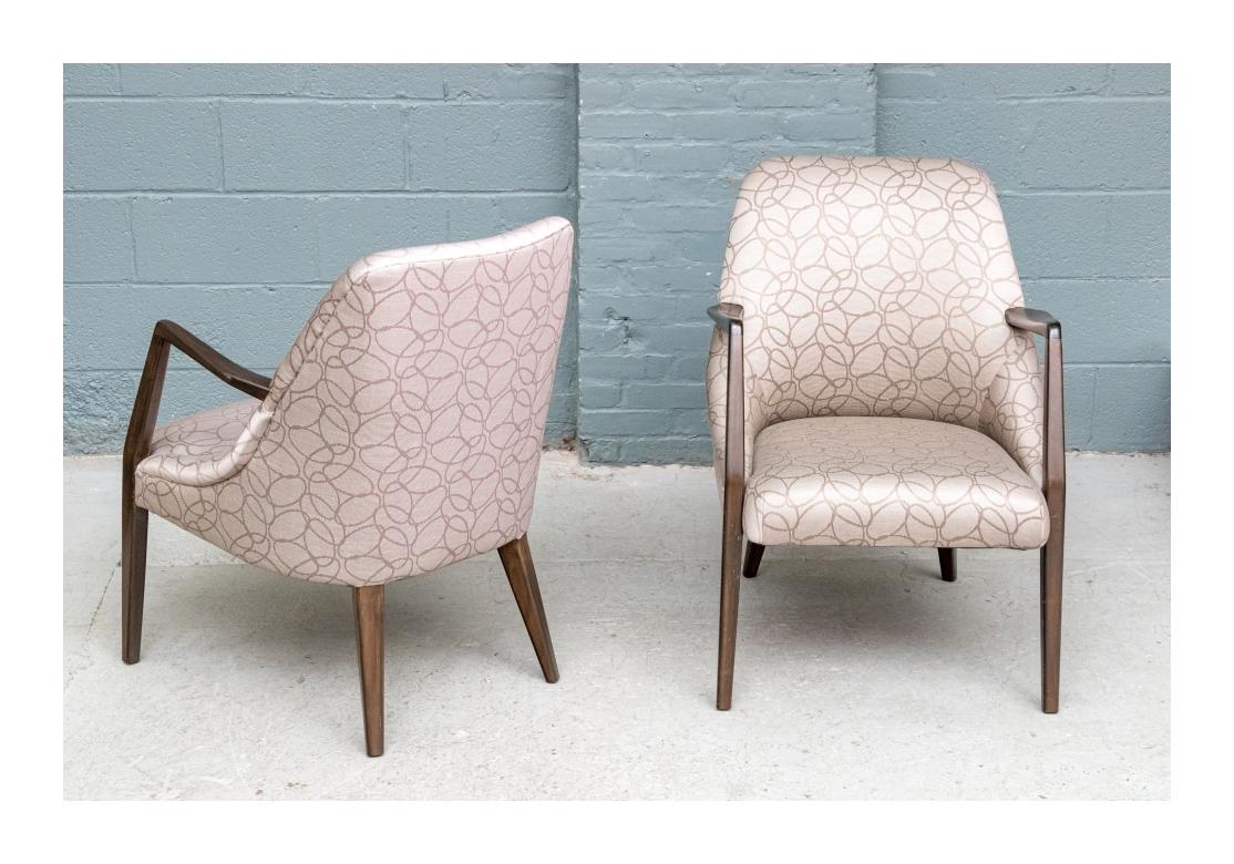 Pair of fine quality Mid Century armchairs each with handsomely carved and dark stained walnut frames with square tapered legs, angular arms and good weight. Each with tight upholstered seats and backs and . Attributed to Bertha