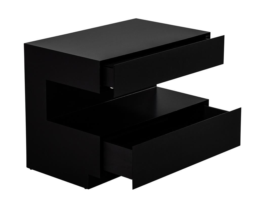 Élevez votre chevet avec cette paire exquise de tables de chevet personnalisées, fabriquées à la main par Carrocel. Fabriquée en noyer riche et finie dans une laque noire satinée sophistiquée, chaque pièce comporte deux grands tiroirs à fermeture