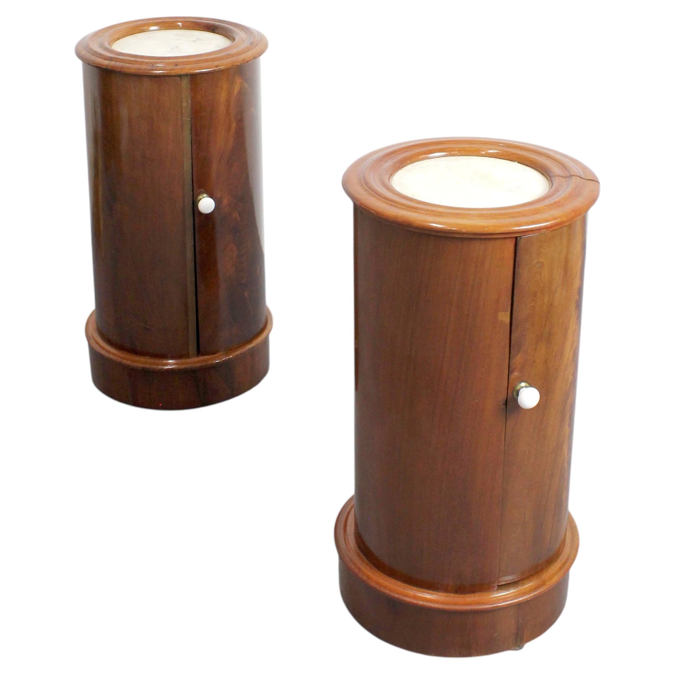 Pair of cylindrical mahogany bedside tables with marble tops