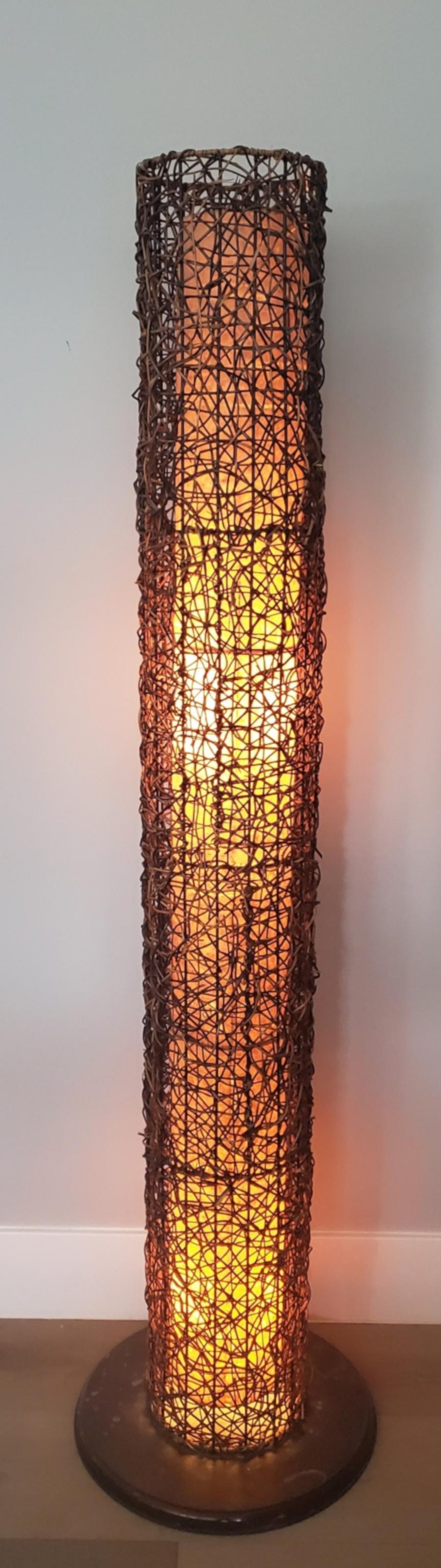 Pair of tall cylindrical rattan and fiber glass floor lamp. Beautiful natural glow of light throughout the inner frame.