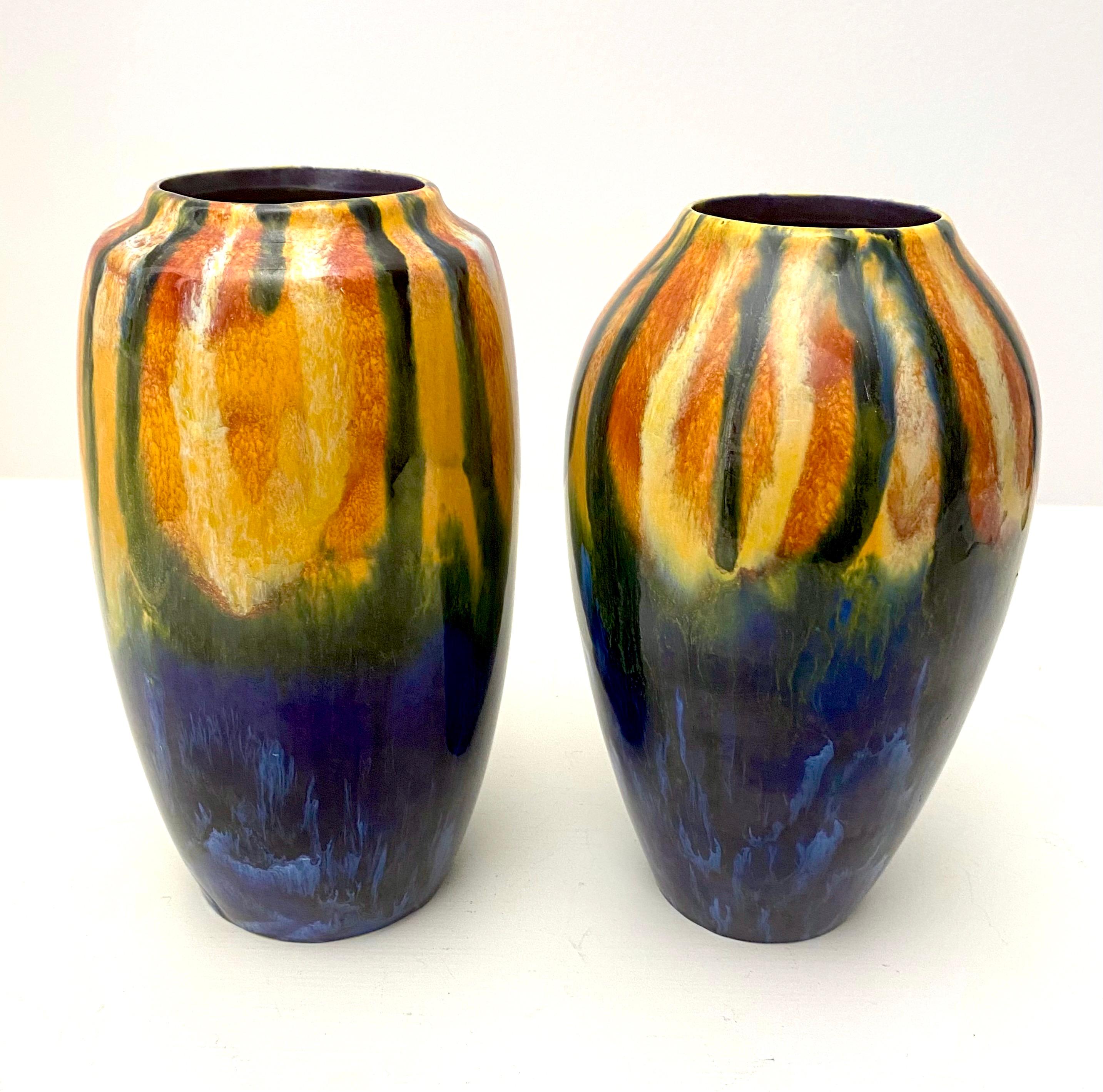 Stunning near pair of cobalt, orange, green, maroon and yellow early czech vases by coronet. A great visual feast for early 20th century collectors. Each one is signed on the bottom and each vase has a slightly different shape and size of the