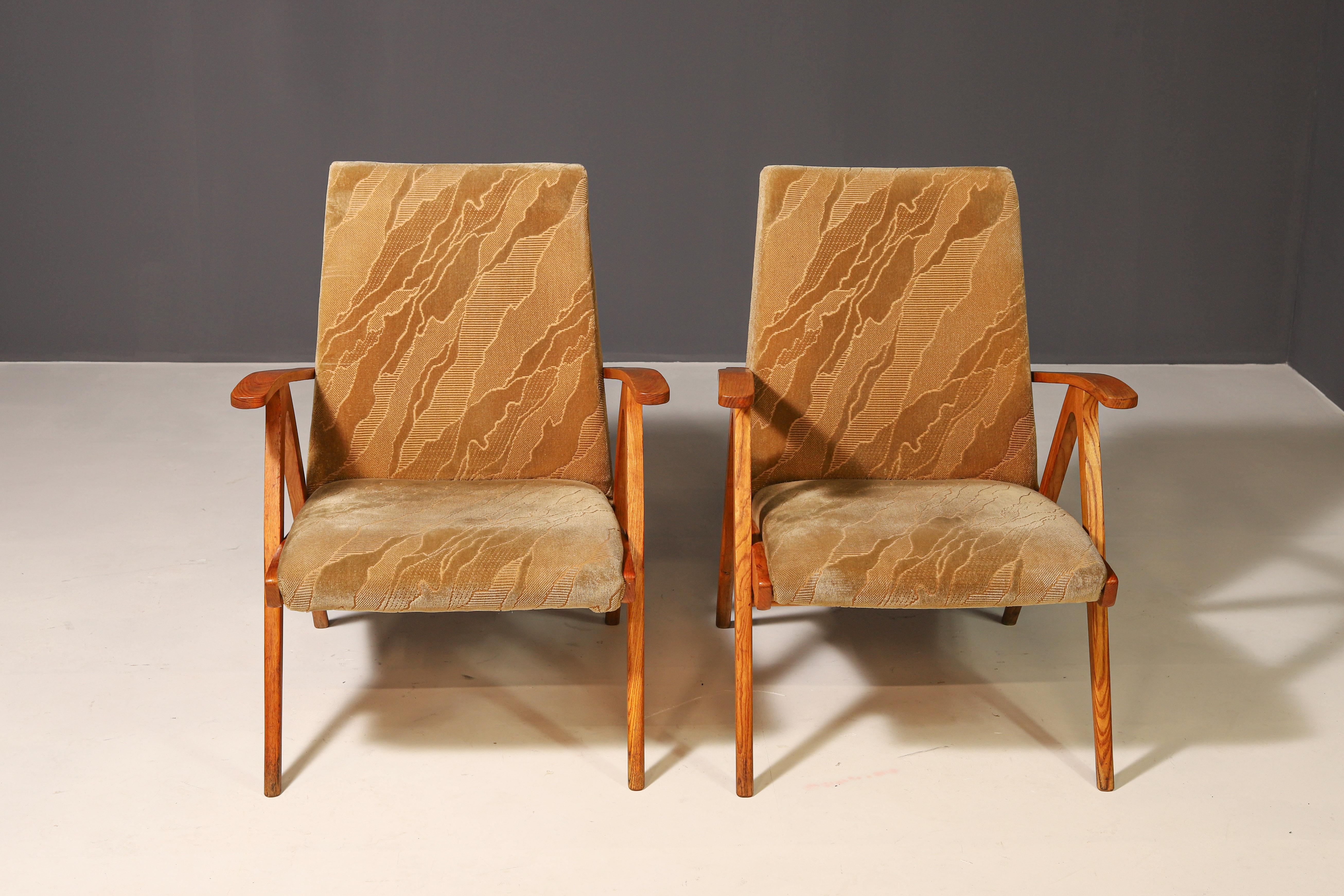 Estos  Los sillones son un ejemplo clásico del mobiliario checoslovaco de mediados del siglo XX. Presentan un elegante armazón de madera con líneas dinámicas y patas ligeramente anguladas, que proporcionan tanto estabilidad como sensación de