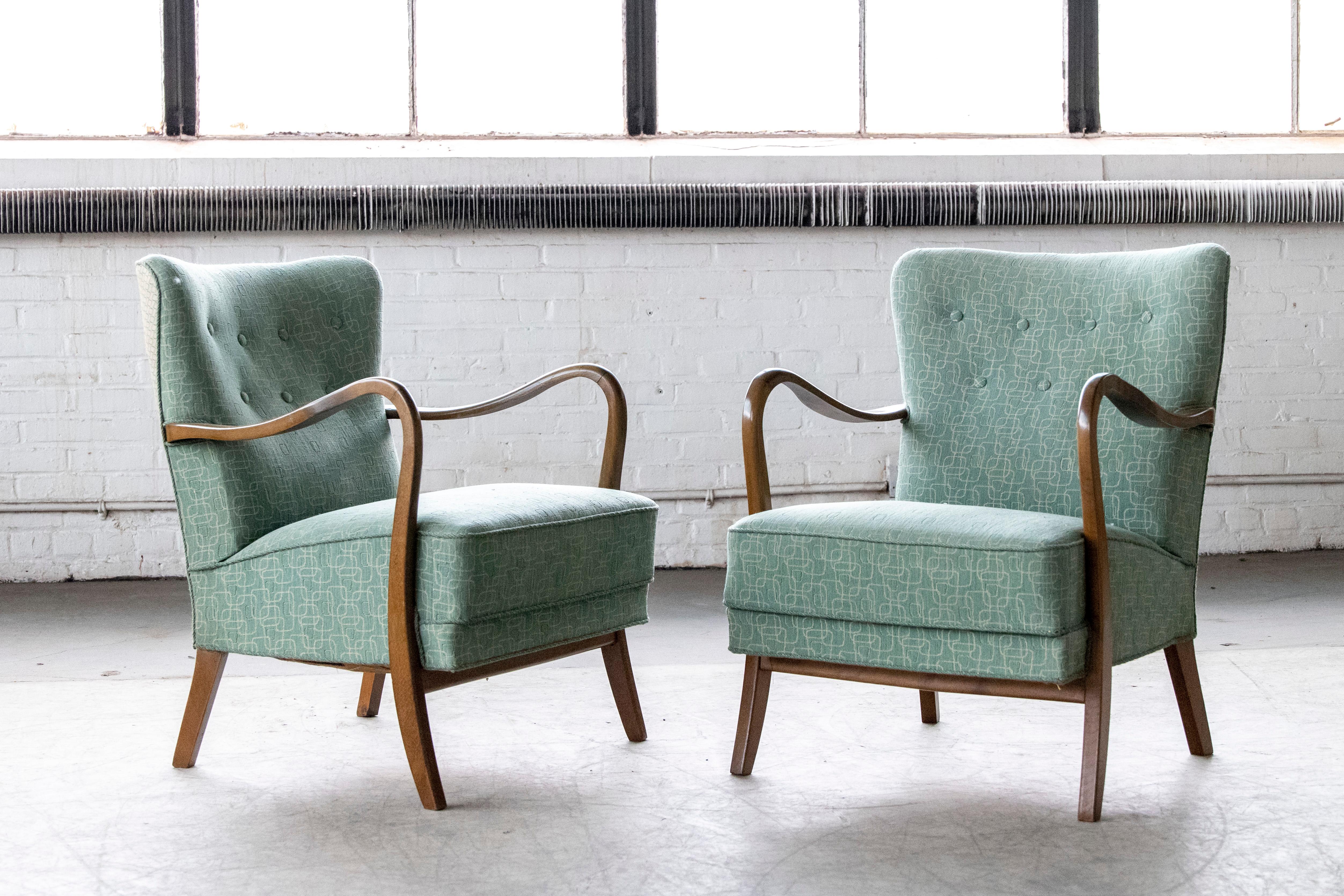 Classic pair of elegant Danish low back armchairs from the 1940s by Alfred Christensen for Slagelse Mobelvaerk with open armrests in beautifully curved stained beech. We love how the armrests extend into the legs. Nice slim elegant silhouette. Solid