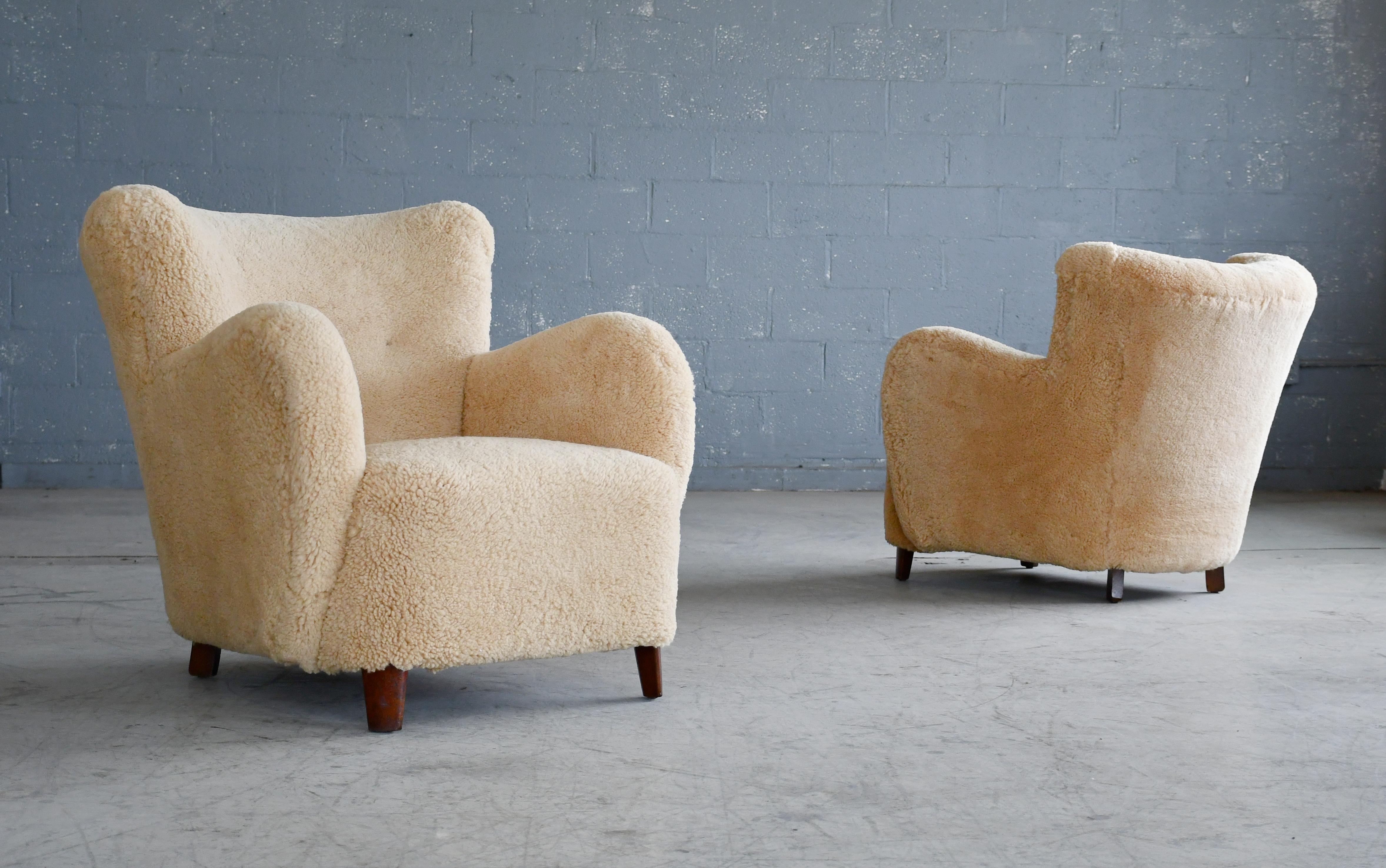 Pair of sublime mid-scale Danish club or lounge chair made in the 1930-40s. The chairs are very similar to Fritz Hansen's famous model 1669 but exhibits a more rounded armrest. We love the low slung voluptuous proportions. These chairs are superbly