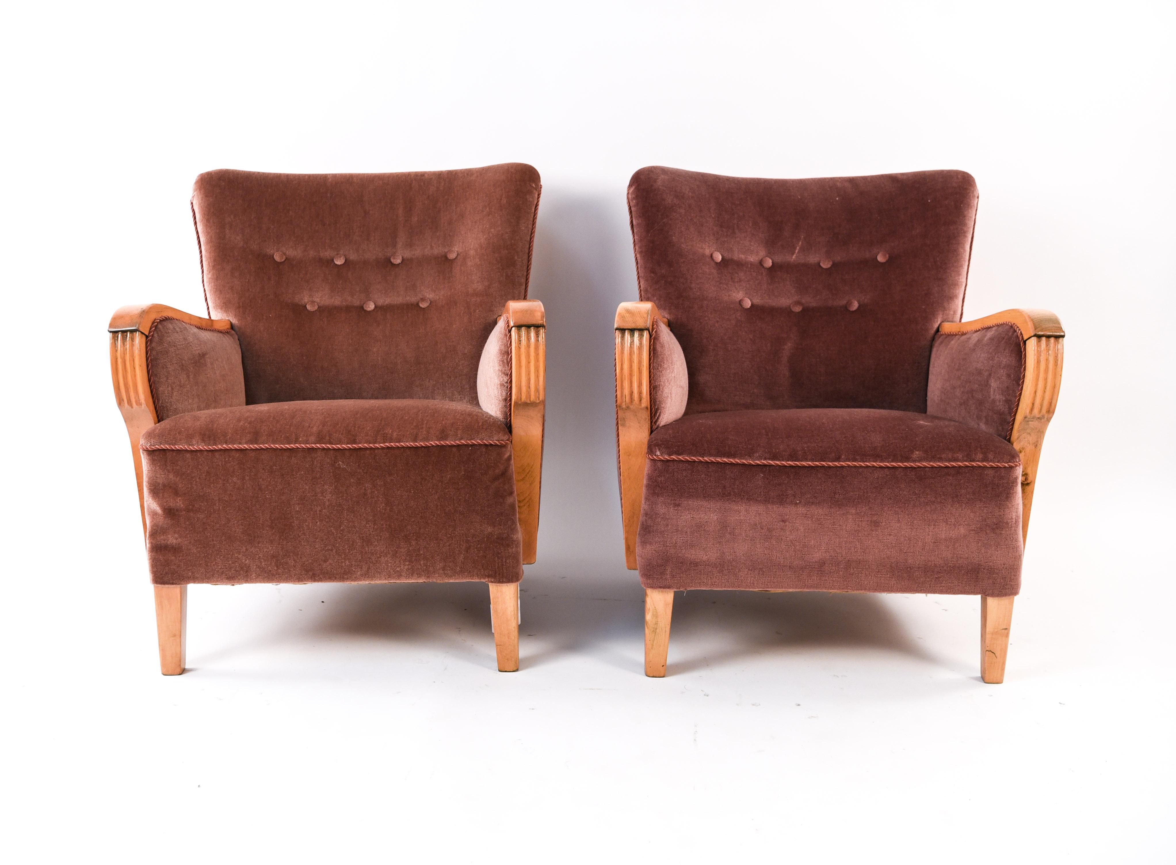 This fun pair of Danish 1940s club chairs is upholstered in a purple velvet-like mohair material. Featuring wood accents with fluted areas along the arms and button tufts on the backs.