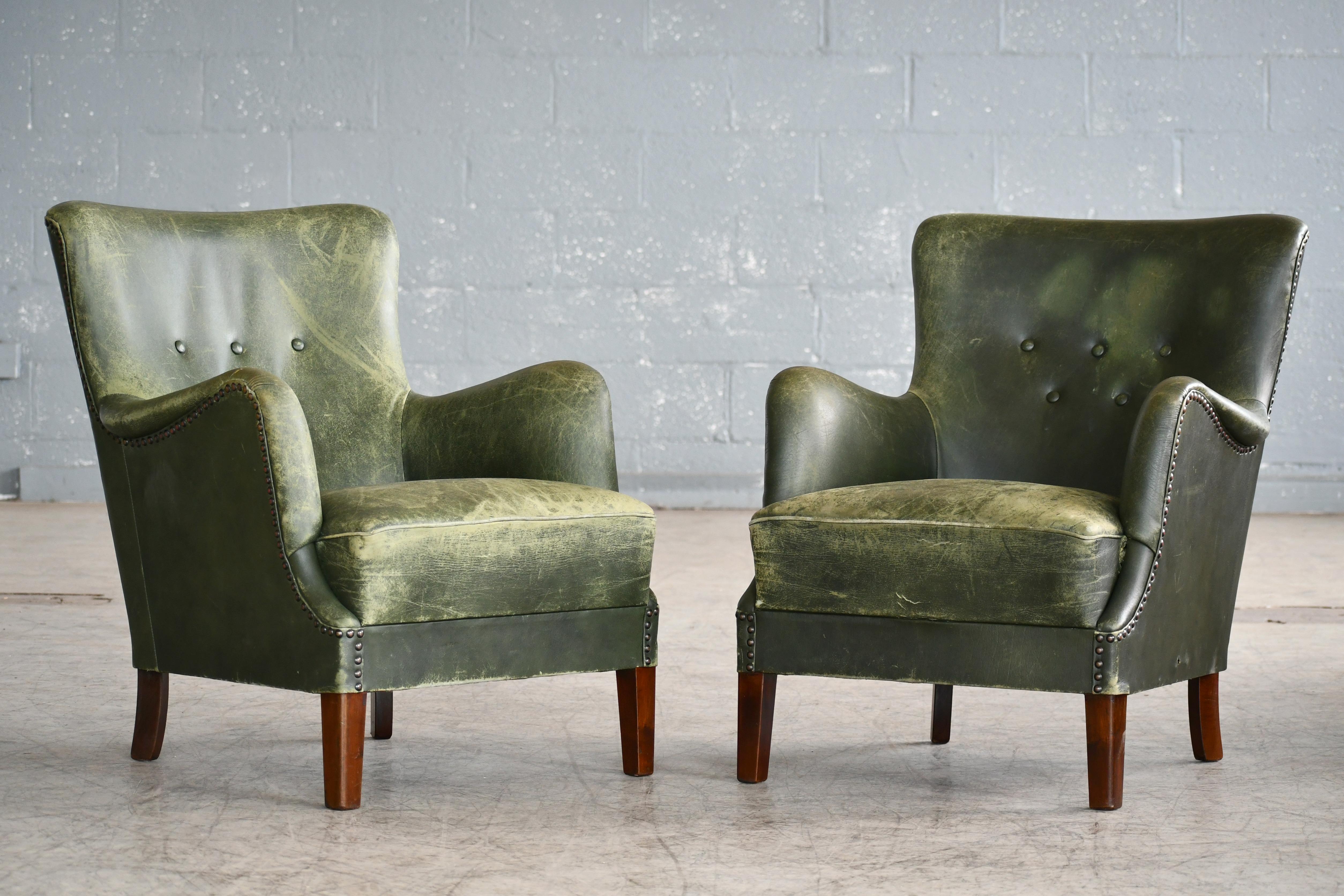 Elegant pair of 1950s small scale lounge chairs attributed to Peter Hvidt and Orla Molgaard made in Denmark between 1940-1950. The chairs exhibit the rolled armrest detail and tapered front legs often preferred by Peter Hvidt. Comfortable and sturdy