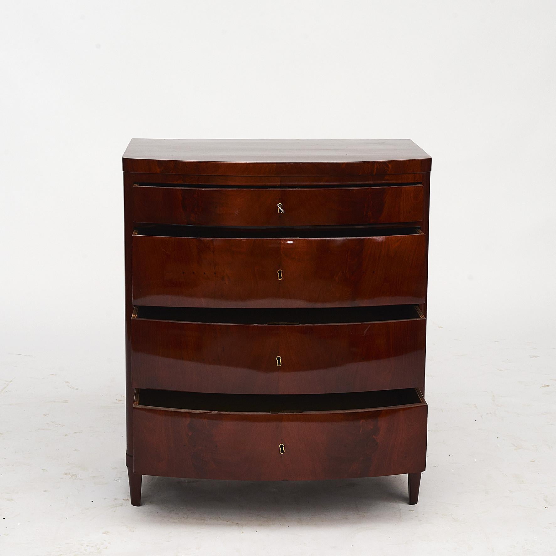 Pair of Danish Empire chest of drawers with bow-front. Mahogany veneered on oak, original brass hardware and key.
Original condition, but finished with a very gentle shellac hand polish (French polish).
Copenhagen, Denmark, circa 1810.