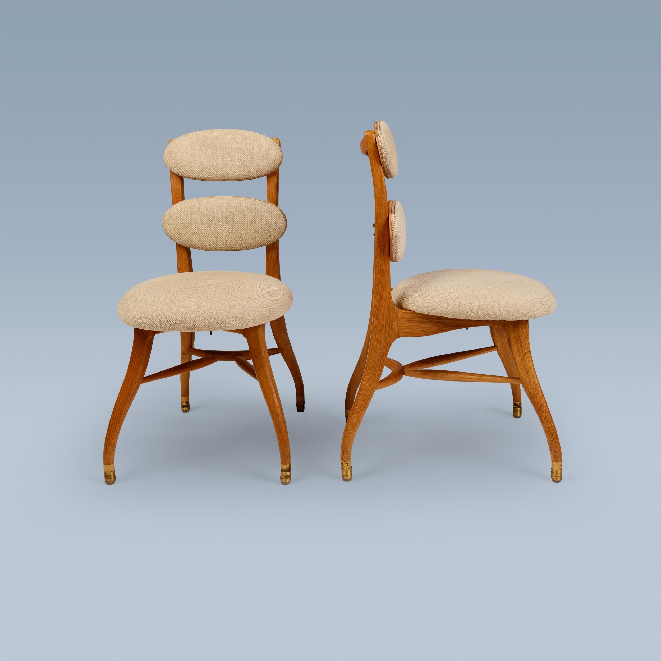 This pair of very rare chairs was designed in 1942 by Vilhelm Lauritzen for the iconic Radiohuset building in Copenhagen. They are designed for the musicians / the orchestra. They have an oak frame and brass feet. Their seats and two backrests can