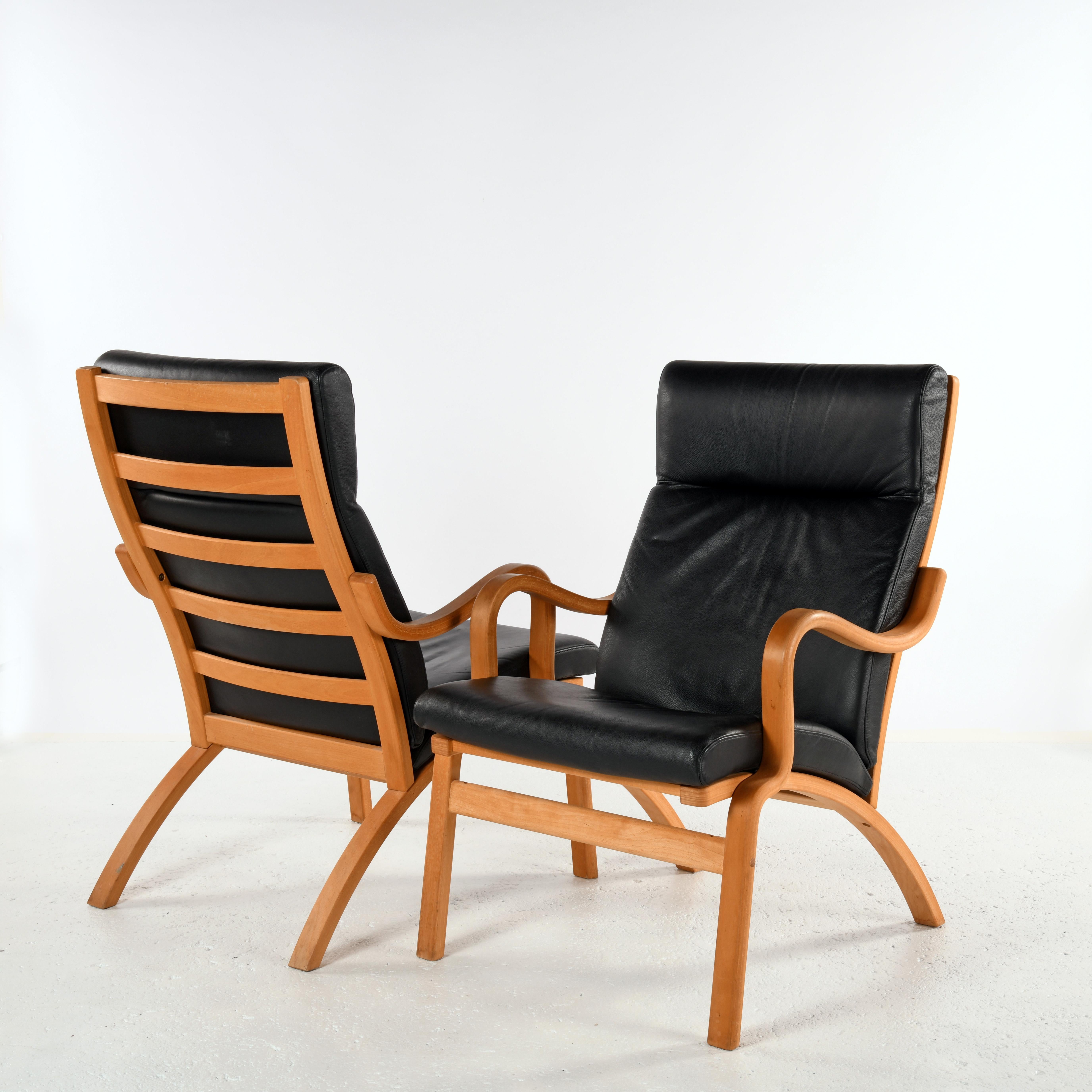 Pair of armchairs produced by Stouby in Denmark. Curved multi-ply beech and black leather, early 20th century edition in perfect condition.  Lightweight, they are easy to move. The high backrest provides excellent back and head support.
The Stouby