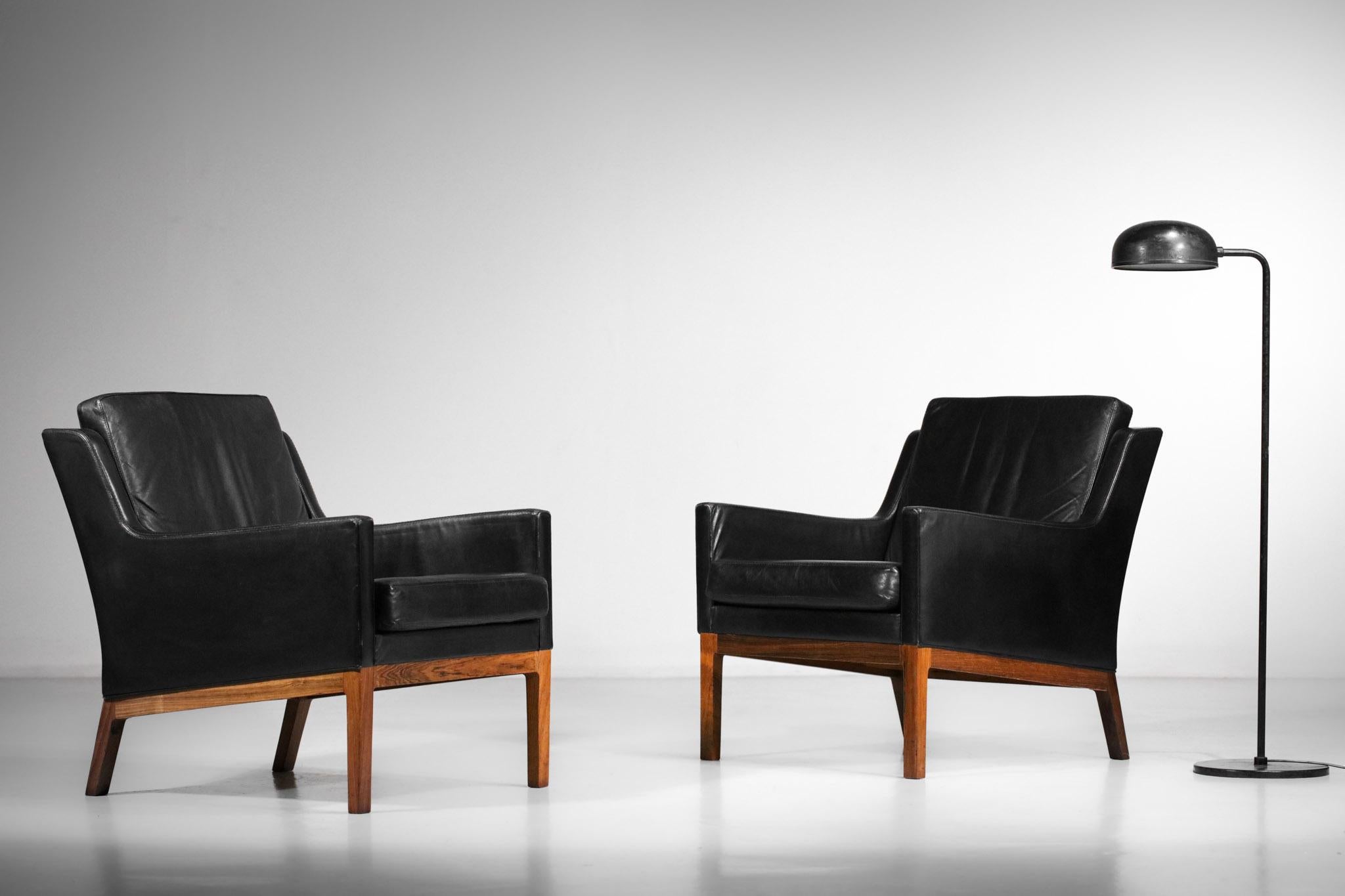 Pair of Scandinavian armchairs by Danish designer Kai Lyngfeldt-Larsen from the 60s. Structure in solid rosewood, seats and backs in black leather. Very nice pair of armchairs with sober and pure lines typical of the Scandinavian design of the time.