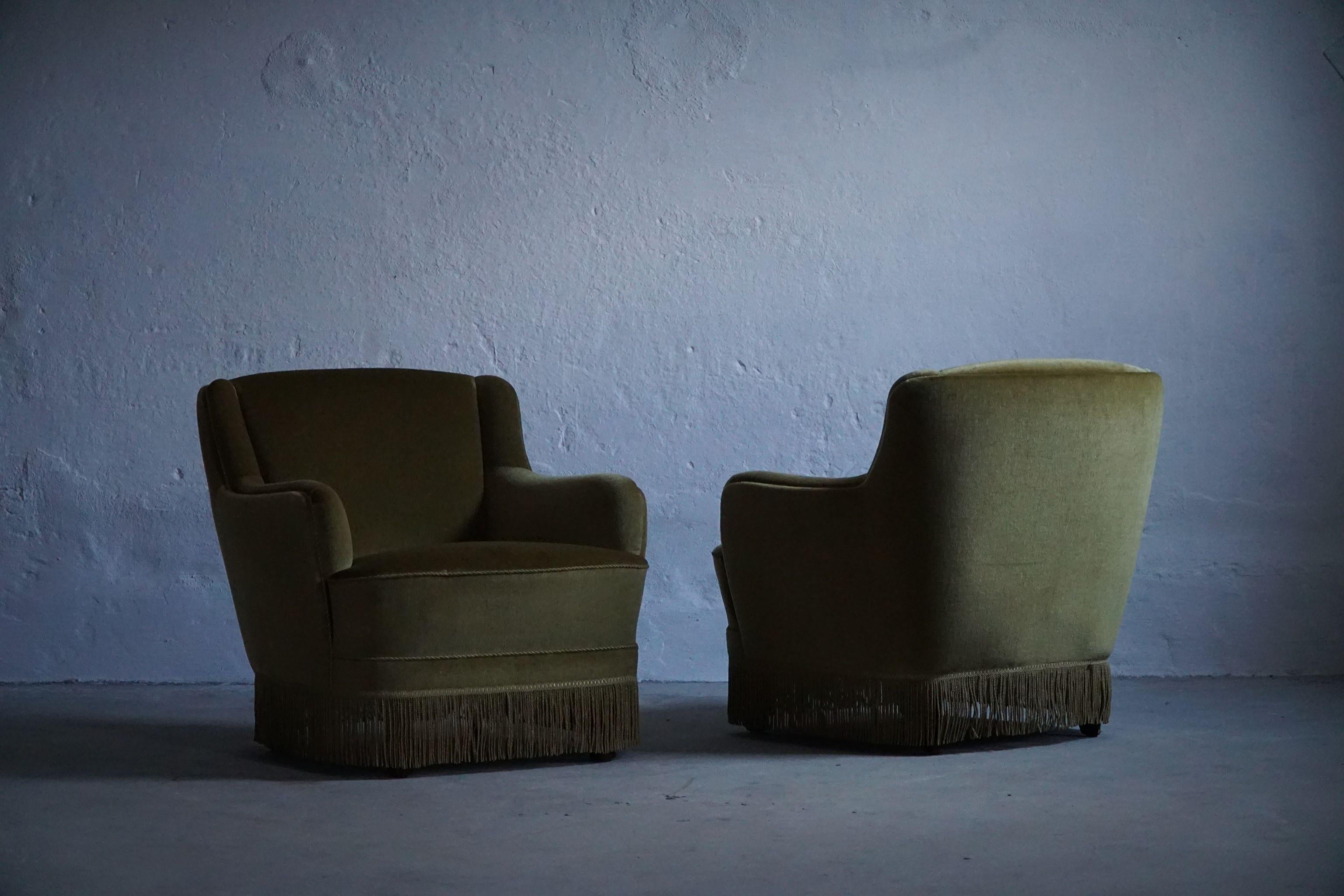 A comfortable pair of Art Deco lounge chairs upholstered in green velvet. Made in 1940s by a Danish Cabinetmaker. 

A nice curved pair in a great vintage condition.

