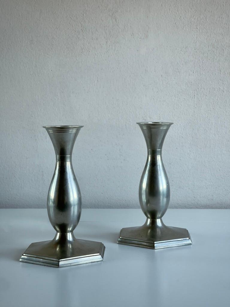 These rare and elegantly shaped 1920s Art Deco candlesticks are the work of renowned Danish sculptor and metalworker Just Andersen. Known for his innovative use of materials, Andersen created these candlesticks from pewter, a material he often