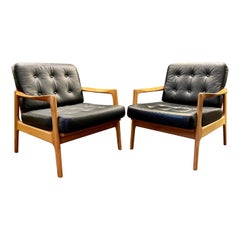 Pareja de sillones daneses de cuero negro y madera de cerezo