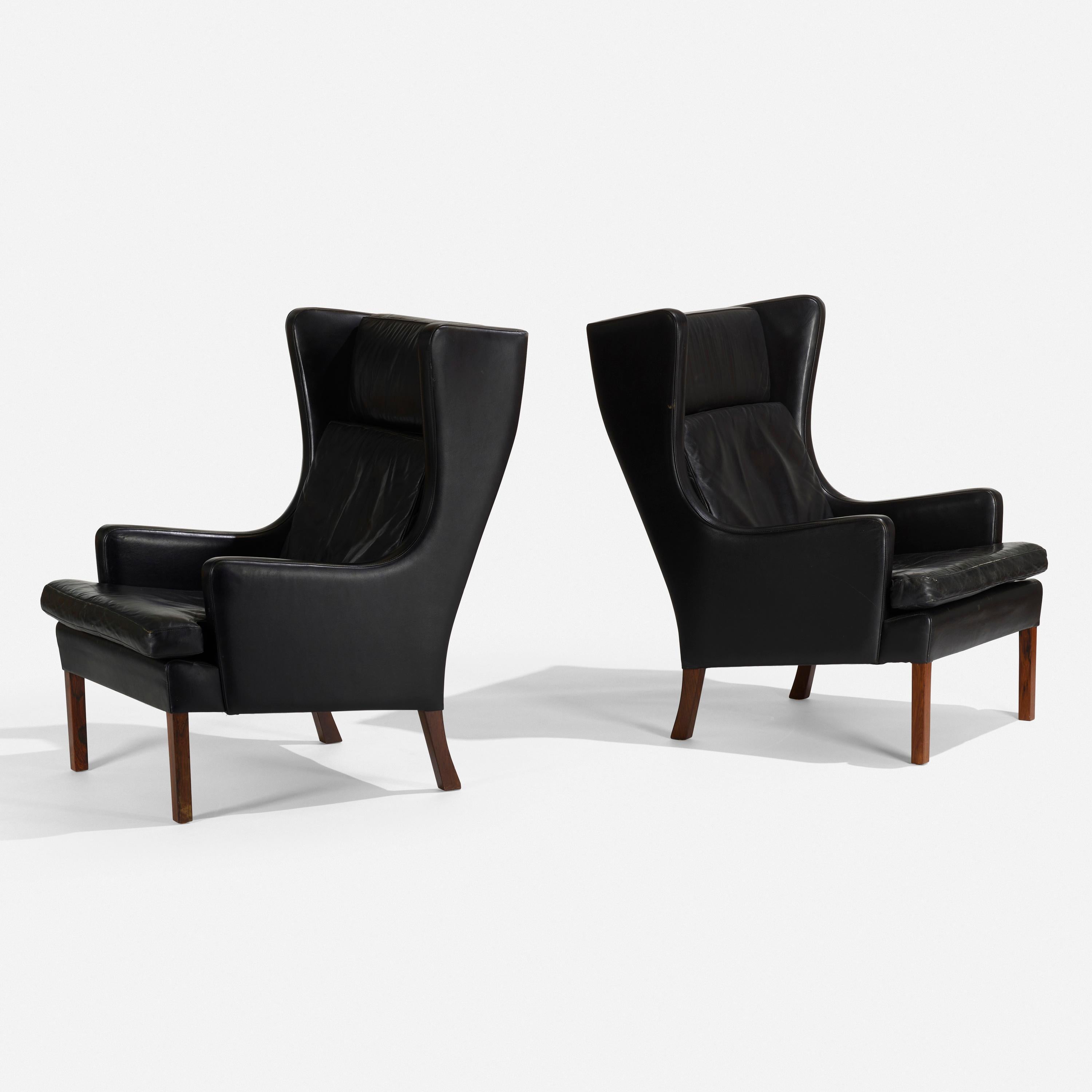 Pair of Danish black leather upholstered wingback chairs.