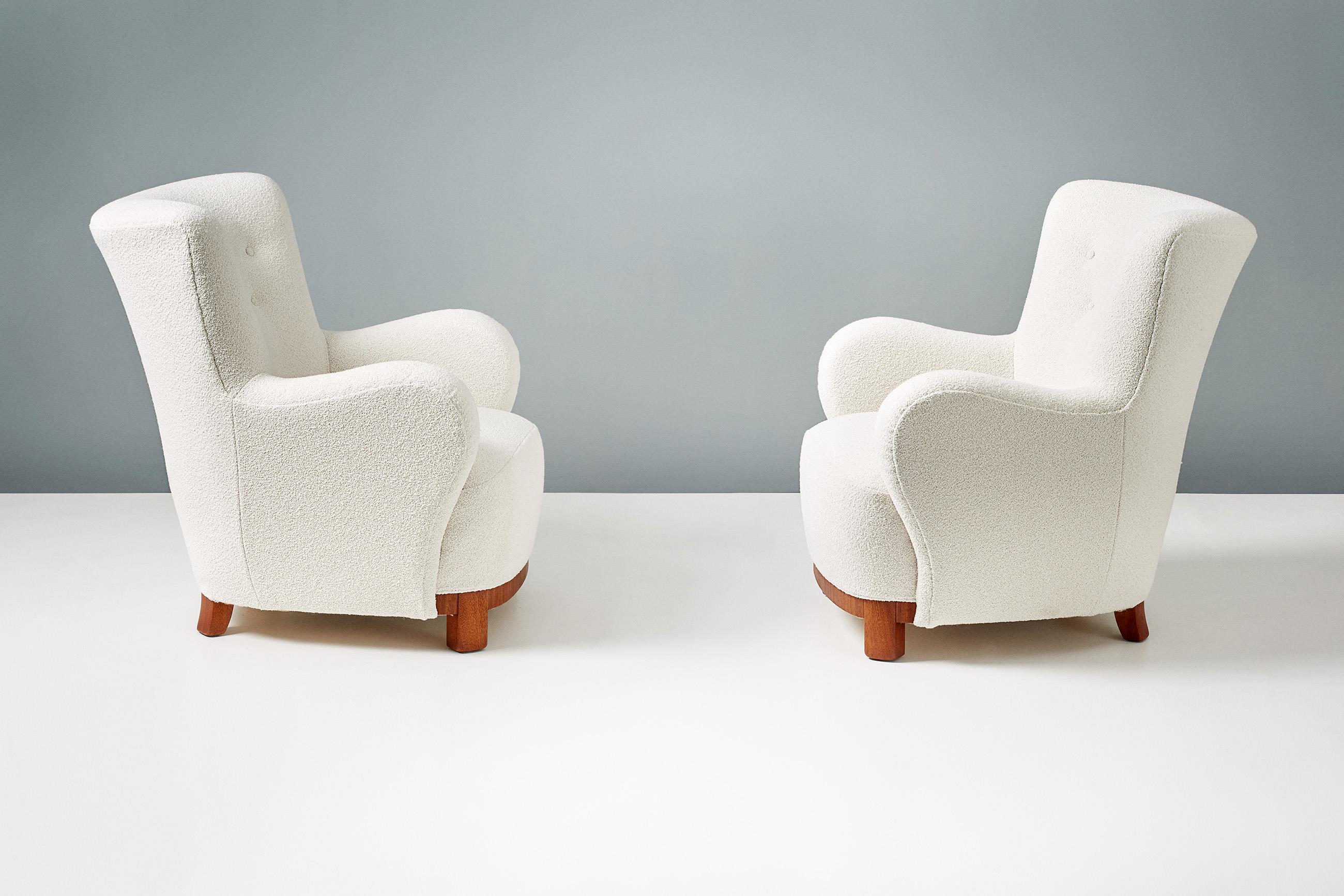 A pair of Danish cabinetmaker 1950s lounge chairs reupholstered in luxurious cotton-wool blend off-white bouclé fabric from Chase Erwin in England. The legs and based are made of African Mahogany. 

Each chair has been fully reconditioned in our