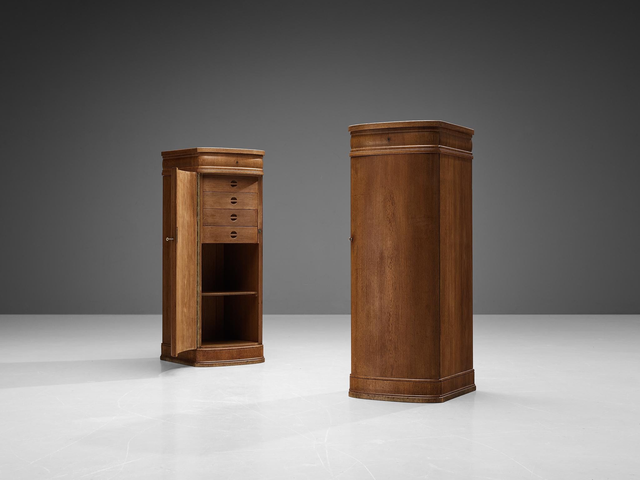 Paire d'armoires, chêne, laiton, feutre, Danemark, années 1940. 

Cette paire d'armoires à chiffonières raffinées est certainement l'œuvre d'un ébéniste qui a su concevoir un meuble de grande qualité. L'excellence de l'artisanat est associée à un
