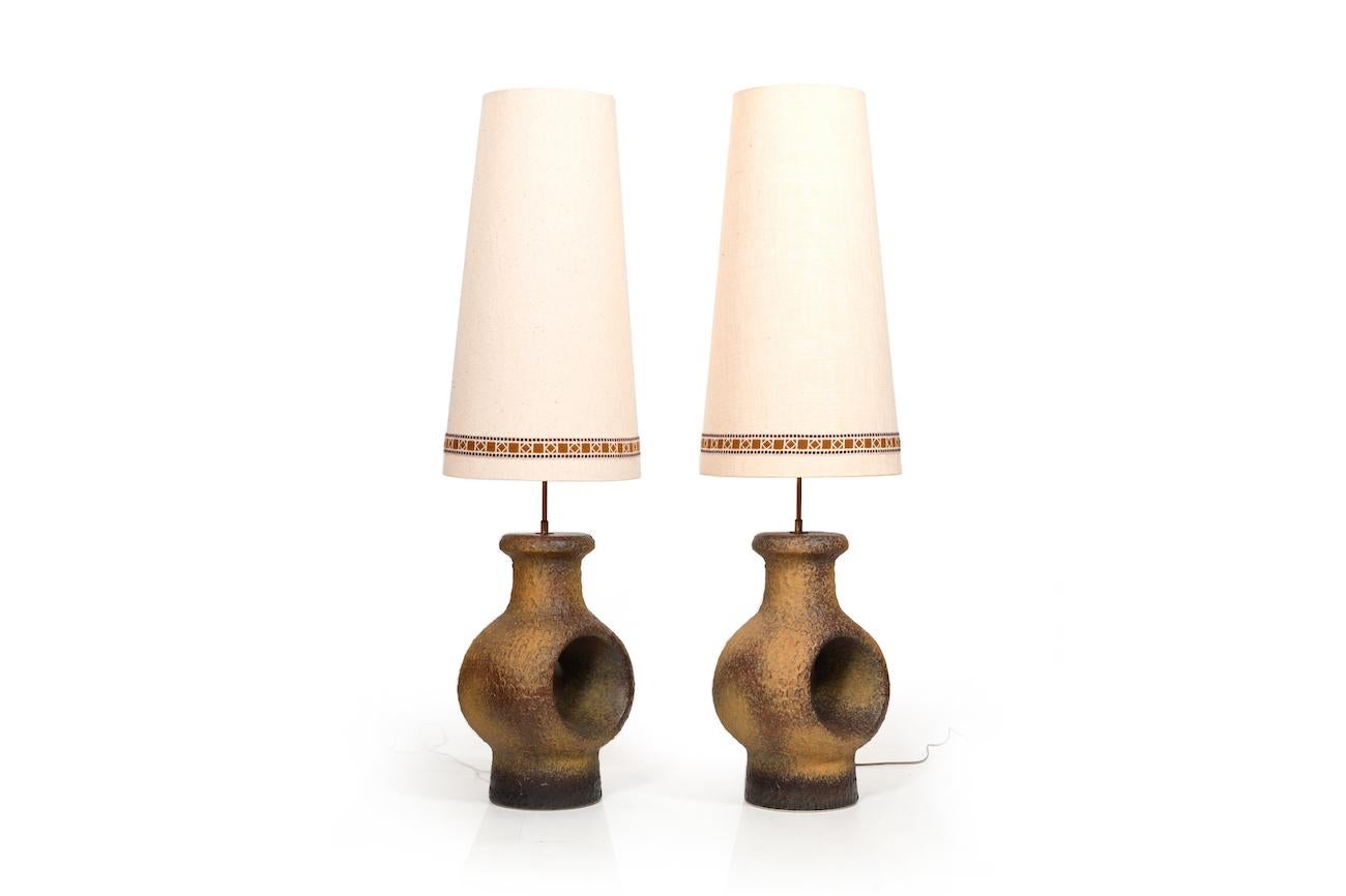 Pair of late 1960s Danish ceramic lamps. They can be used as table - or as floor lamps. With the original fabric lampshades.