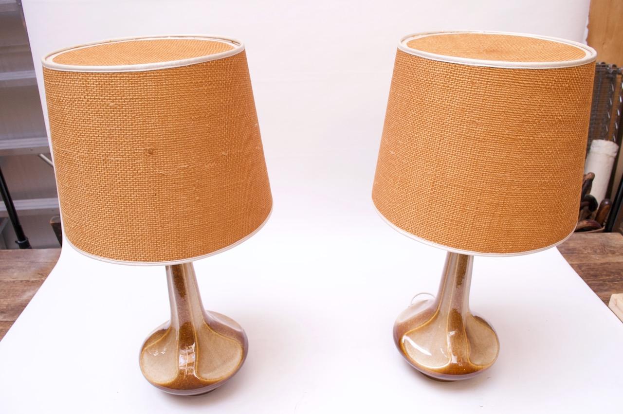 Pair of Danish Modern ceramic table lamps designed in the 1960s by Einar Johansen for Søholm. Ceramic bases boast a rich high-gloss caramel glaze. All accessories are original: the bronze harps fitted to the sockets hold acrylic tops that support