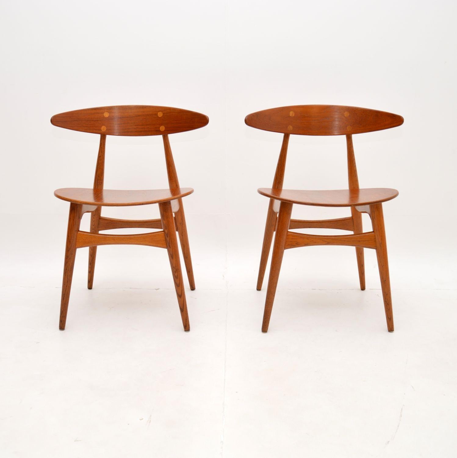 Superbe paire de chaises danoises CH33 de Hans Wegner pour Carl Hansen & Son. Il s'agit de modèles vintage originaux datant des années 1960.

La qualité est exceptionnelle, ils sont magnifiquement fabriqués avec des cadres en chêne massif, les