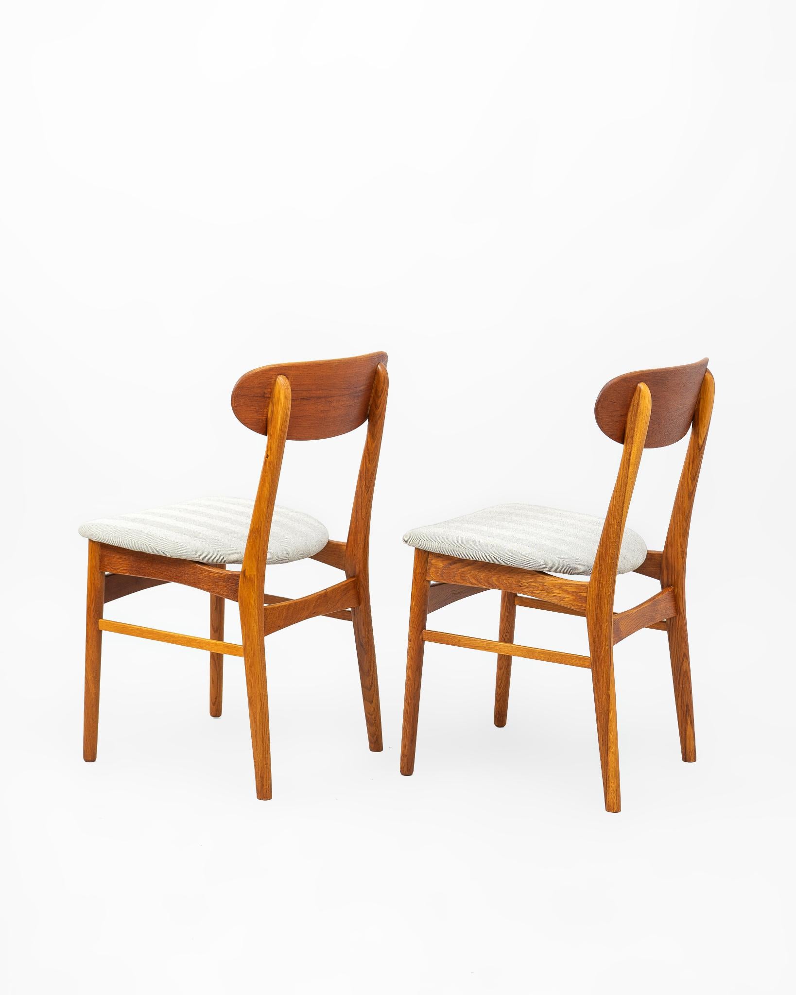 Pareja de sillas en madera de teca fabricadas en Dinamarca en la década de 1960’s. La estructura se construye en madera maciza de teca con un asiento tapizado en tejido de telar tradicional en espiga negra. El respaldo se fabrica en chapa de teca