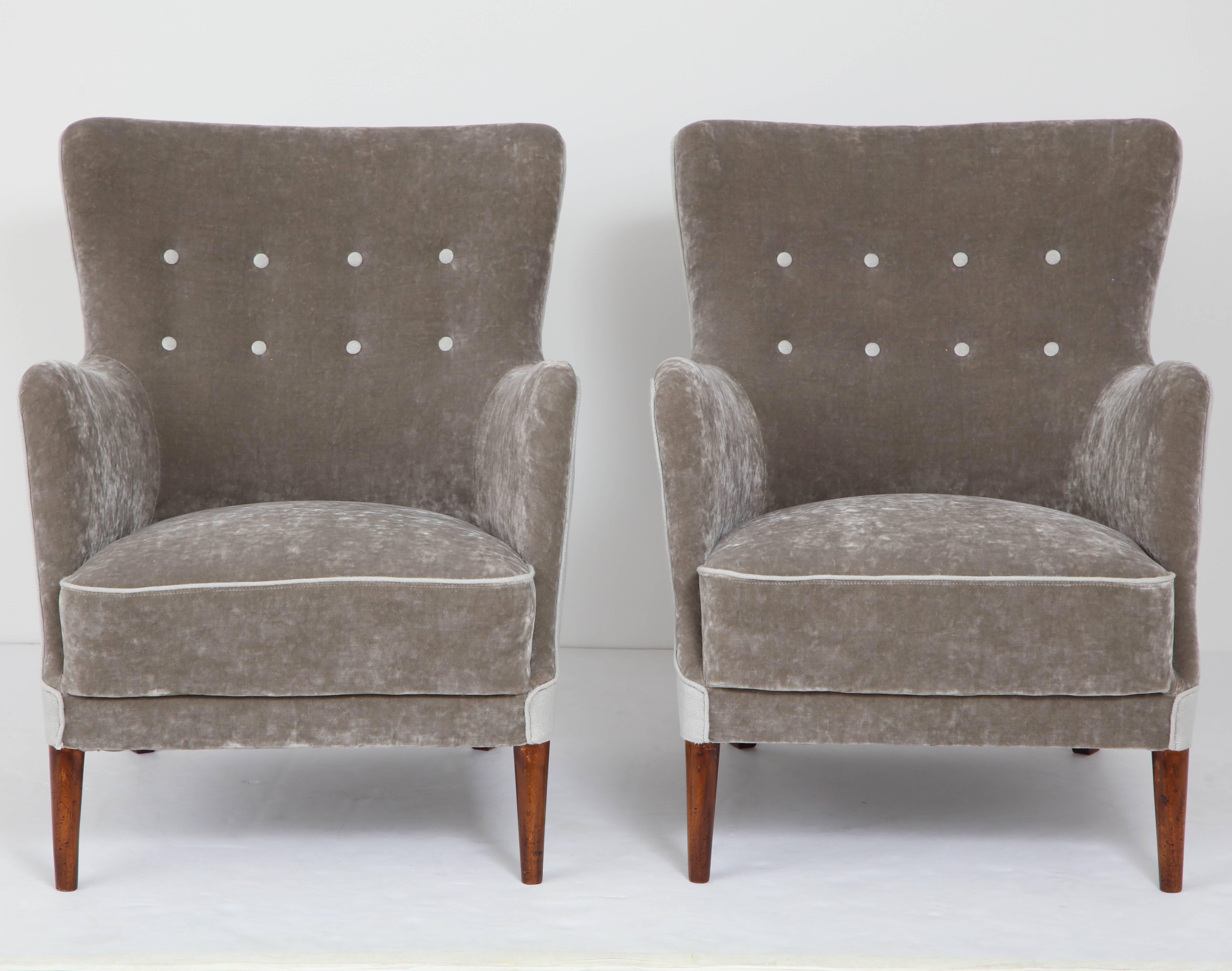 A pair of Danish club chairs, circa 1940s, re-upholstered with two-tone velvet and linen, stained beechwood legs.