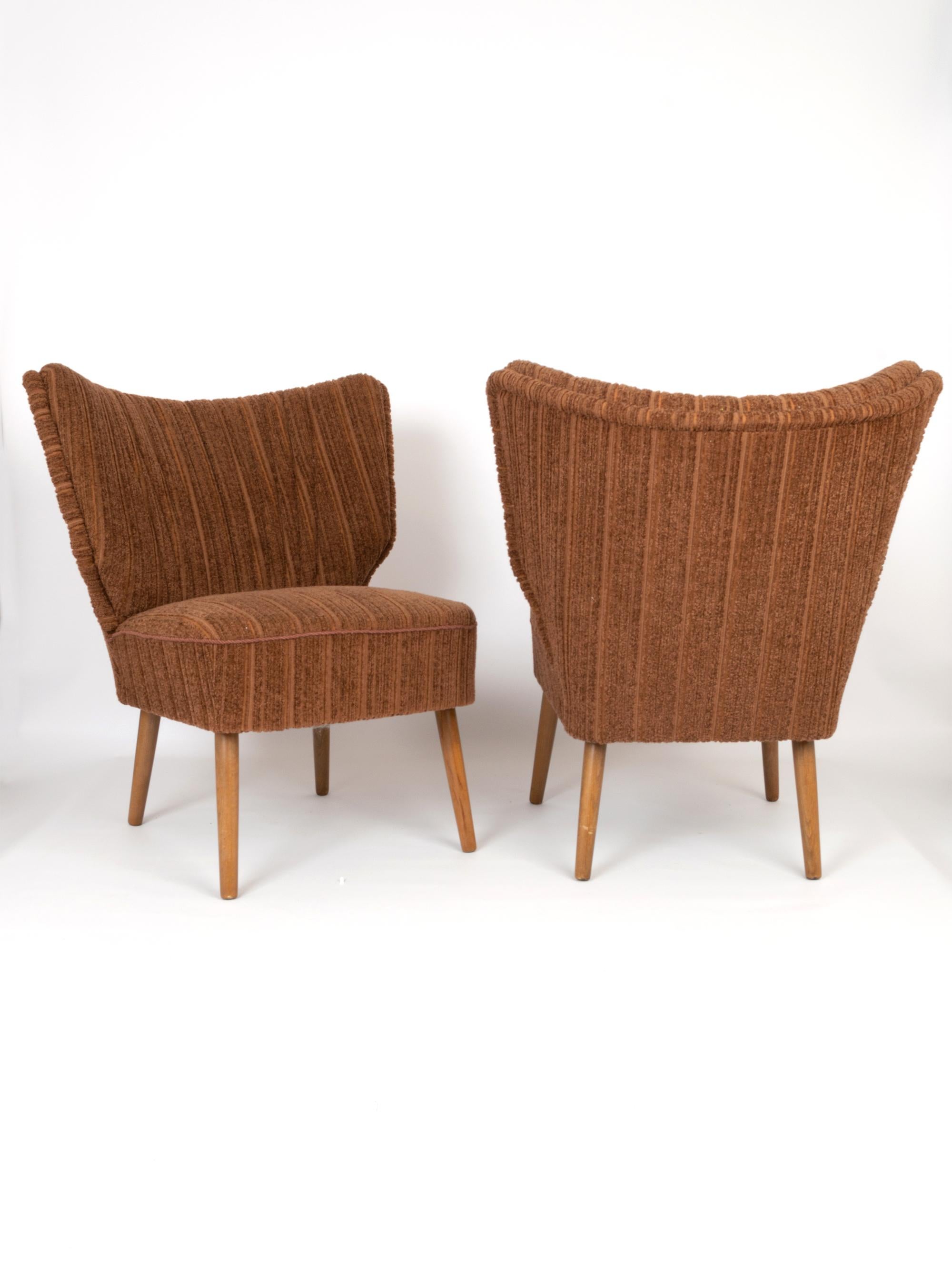Une élégante paire de chaises de cocktail danoises d'origine datant de C.C. 1950. 
La tapisserie et le tissu d'origine sont présentés en excellent état vintage. Les pieds en teck sont solides et sains.