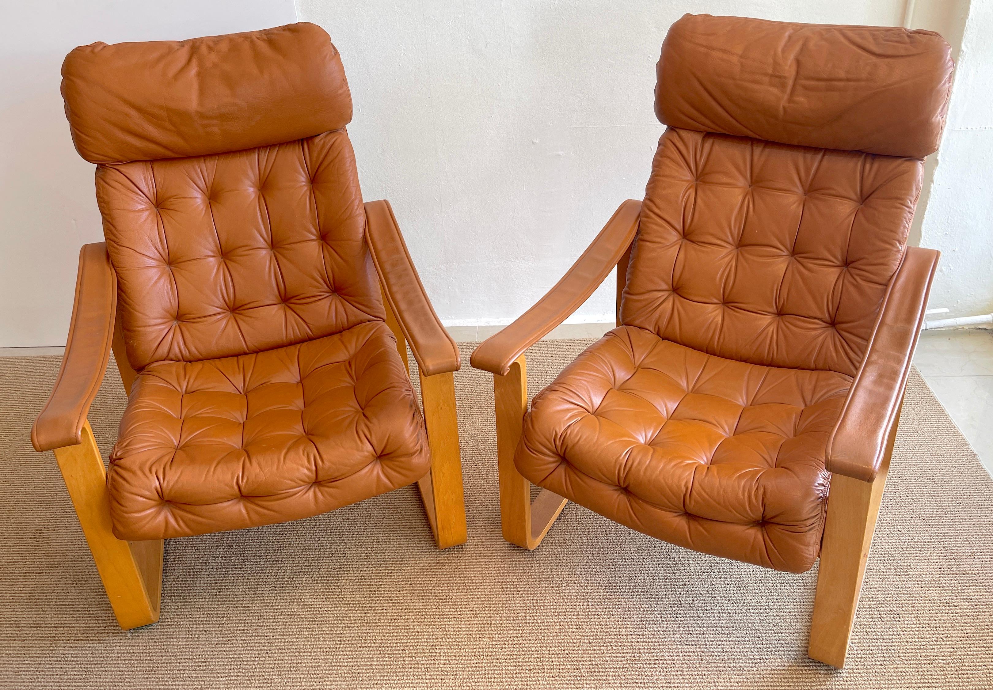 Pair of Danish cognac leather club chairs, circa 1960s 
Made in Finland by OY BJ. Dahlqvist for Hounekalutehads-Mobelfabrik.
The leather tufted leather backrest and seats and armrest, supported by bentwood frames.
Each chair measures 38