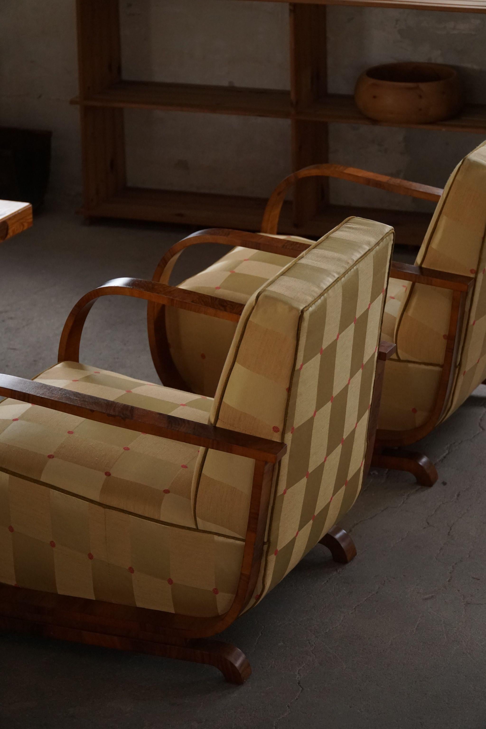 Pair of curved Art Deco lounge chairs, with armrest in walnut, made in 1930s by a Danish cabinetmaker. Beautiful wood grains that complementary these glamorous chairs. 

The overall impression of these vintage chairs are really good.

