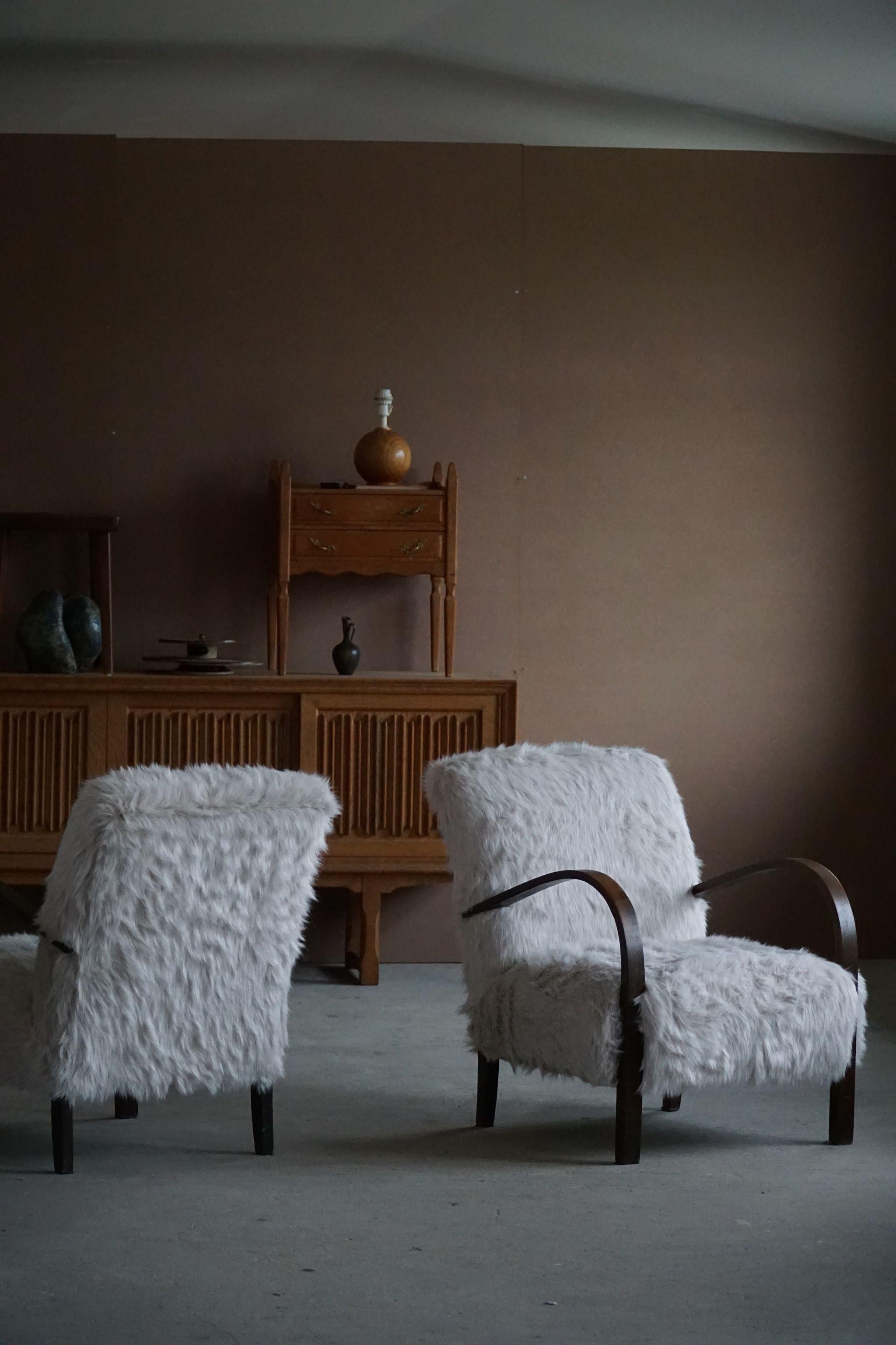 Beautiful pair of Art Deco lounge chairs, reupholstered in plush an imitation of lambswool. Made by a Danish cabinetmaker, ca 1940s. 
A simple and refined design that will combine well with the modern interior.

Both chairs are in a great vintage