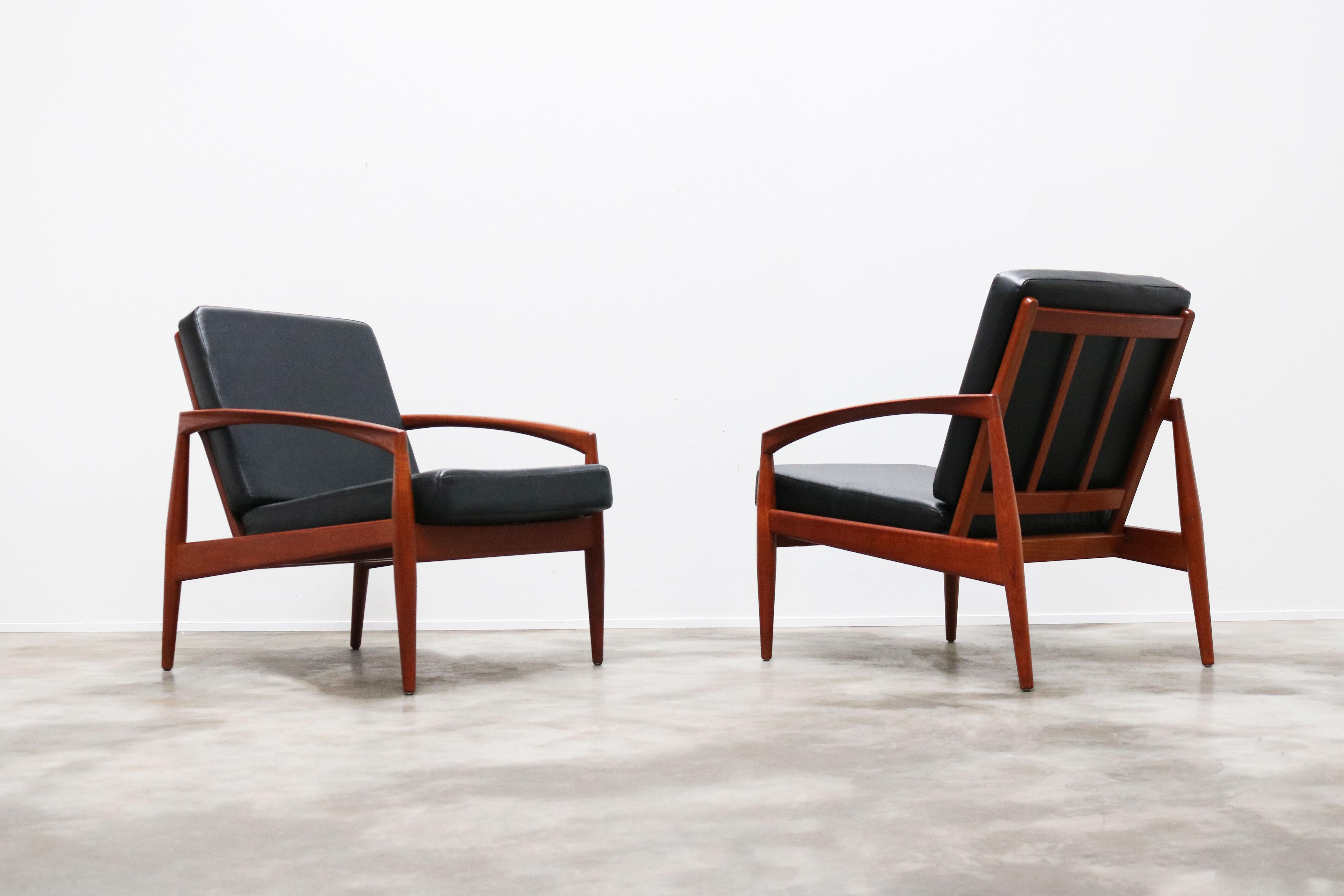 Rare pair of 'Paper Knife' model 121 lounge chairs in teak and black leather (faux) design by Kai Kristiansen for Magnus Olesen in 1955. 
Gorgeous organic design style sculpted in solid teak.
Very comfortable chairs and true design classics.
Both
