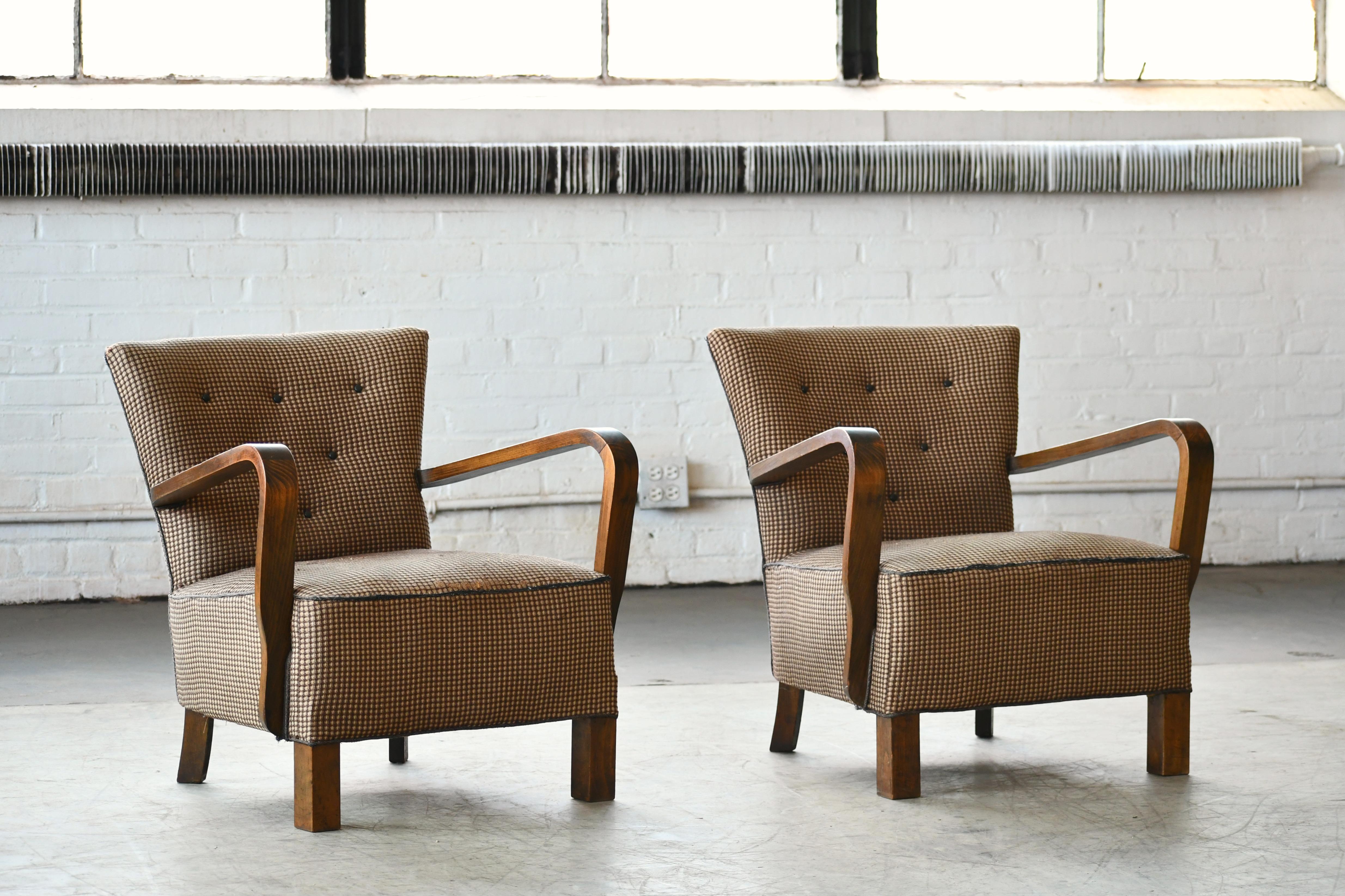 Superb pair of Danish late Art Deco early midcentury chairs from the early 1940s with spring cushions and beautiful open armrests and legs carved in solid mahogany with great grain and patina. We just love the simple yet very refined elegant and fun