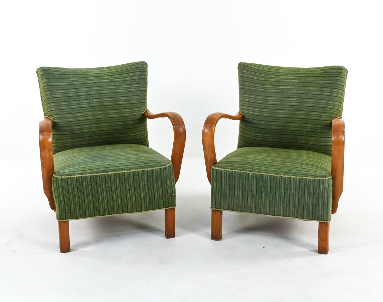 This classic pair of Danish Mid-Century lounge chairs features chunky legs and gracefully curved arms of sculpted elm wood. The striped wool upholstery is playfully offset to create an interesting mix of vertical and horizontal lines. The seat rails