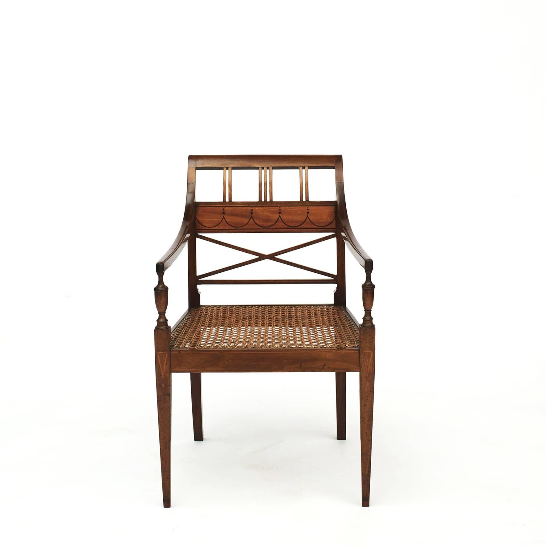 Pair of elegant Empire armchairs in mahogany and satinwood.
Satinwood and walnut wood marquetry inlaid on back, front frieze and legs.
Seat with wicker (one renewed). 
Denmark, Copenhagen approx. 1810.

Measure: Seat height: 42 cm.
 