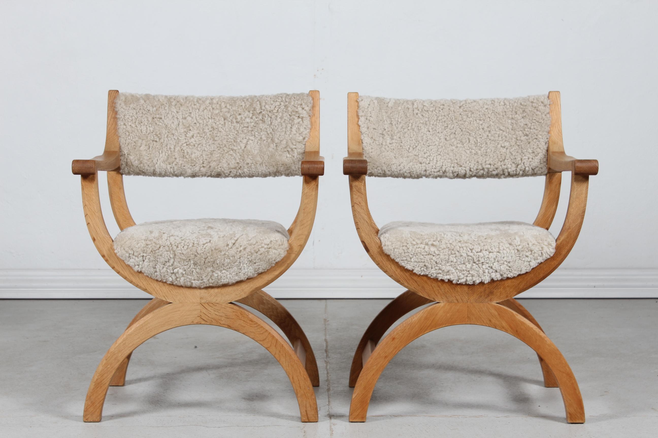 A pair of Danish vintage Henning Kjærnulf kurul chairs with armrest manufactured by EG / Nyrup Møbler in Denmark

The armchairs are made of solid oak upholstered with new sheepskin which is very comfortable and 