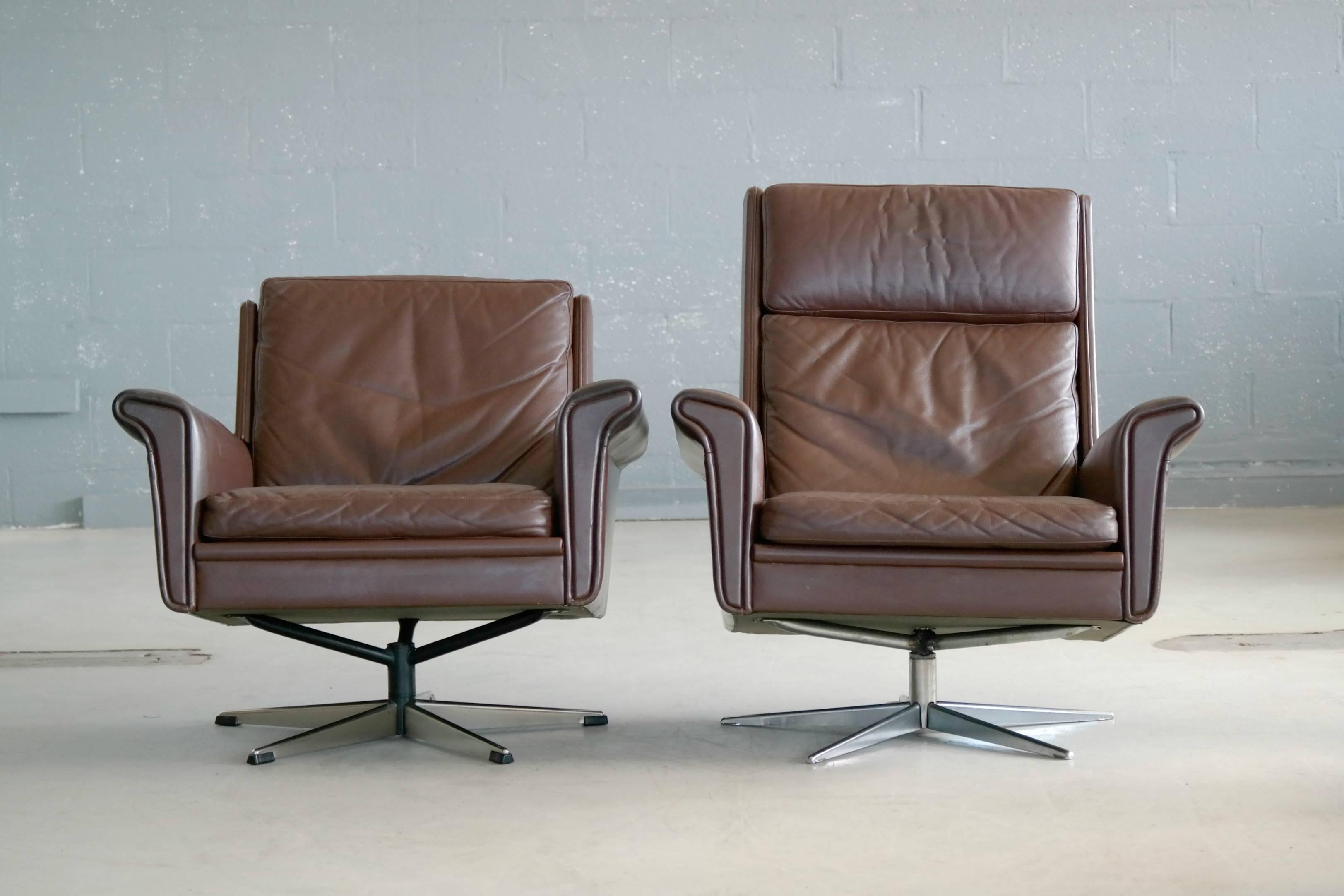 Modern and luxurious swivel chairs in supple brown chocolate colored leather on a chrome-plated aluminium swivel base. Beautiful example of Danish Modern at its best designed by Georg Thams, circa 1969 and produced sometimes in the early 1970s. The