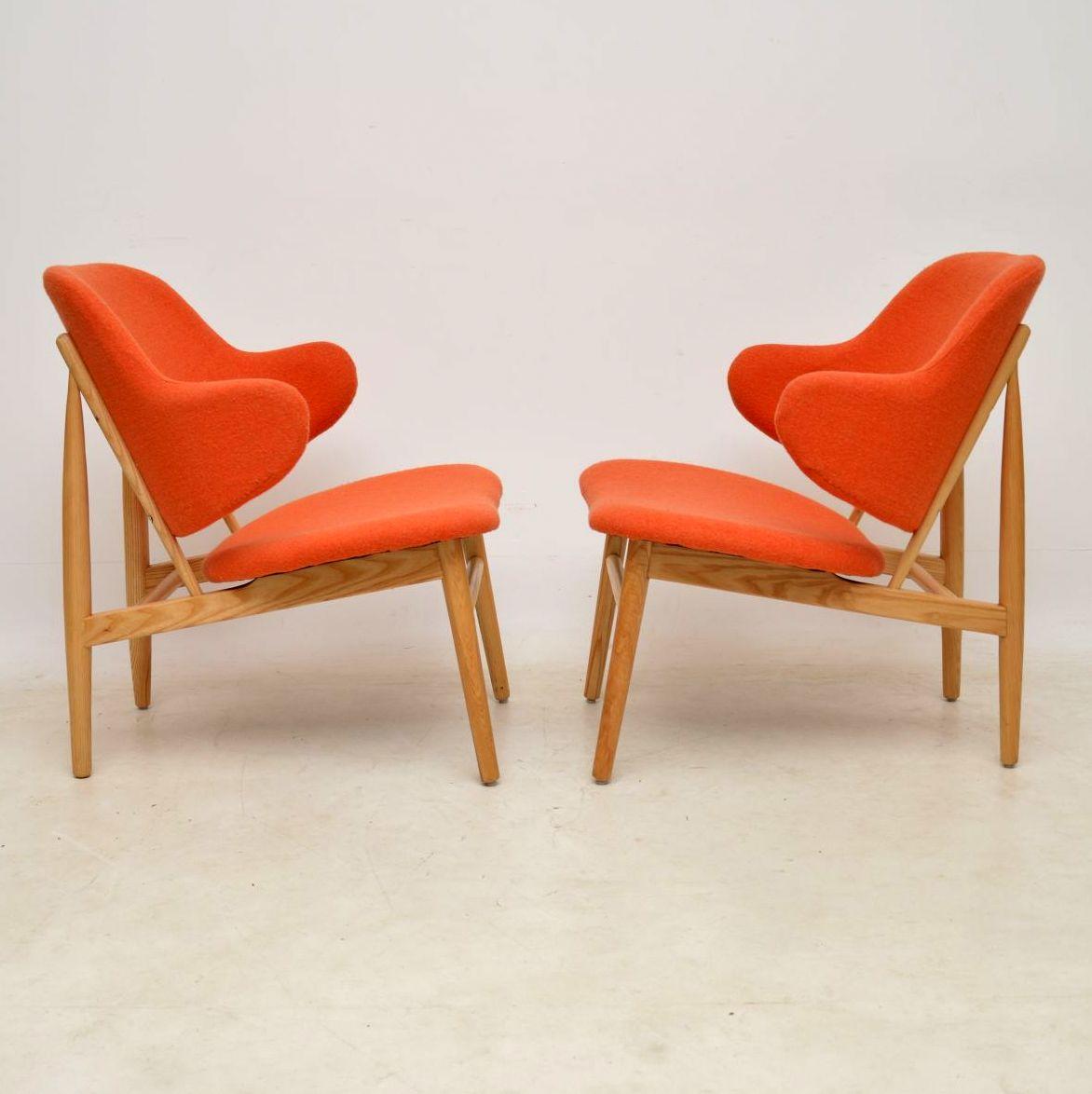 A stylish and extremely comfortable pair of armchairs, these are by the famous Danish designer IB Kofod Larsen. They are beautifully made from solid ash, and are covered in a lovely soft pale orange upholstery. The condition is excellent throughout,