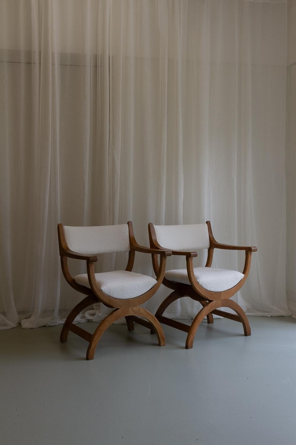 Danish Kurul Armchairs in Oak and Bouclé by Henning Kjaernulf for EG Kvalitetsmøbel, Denmark, 1960s. Set of 2.

This matching pair of Scandinavian Modern Curule chairs in solid European white oak model 