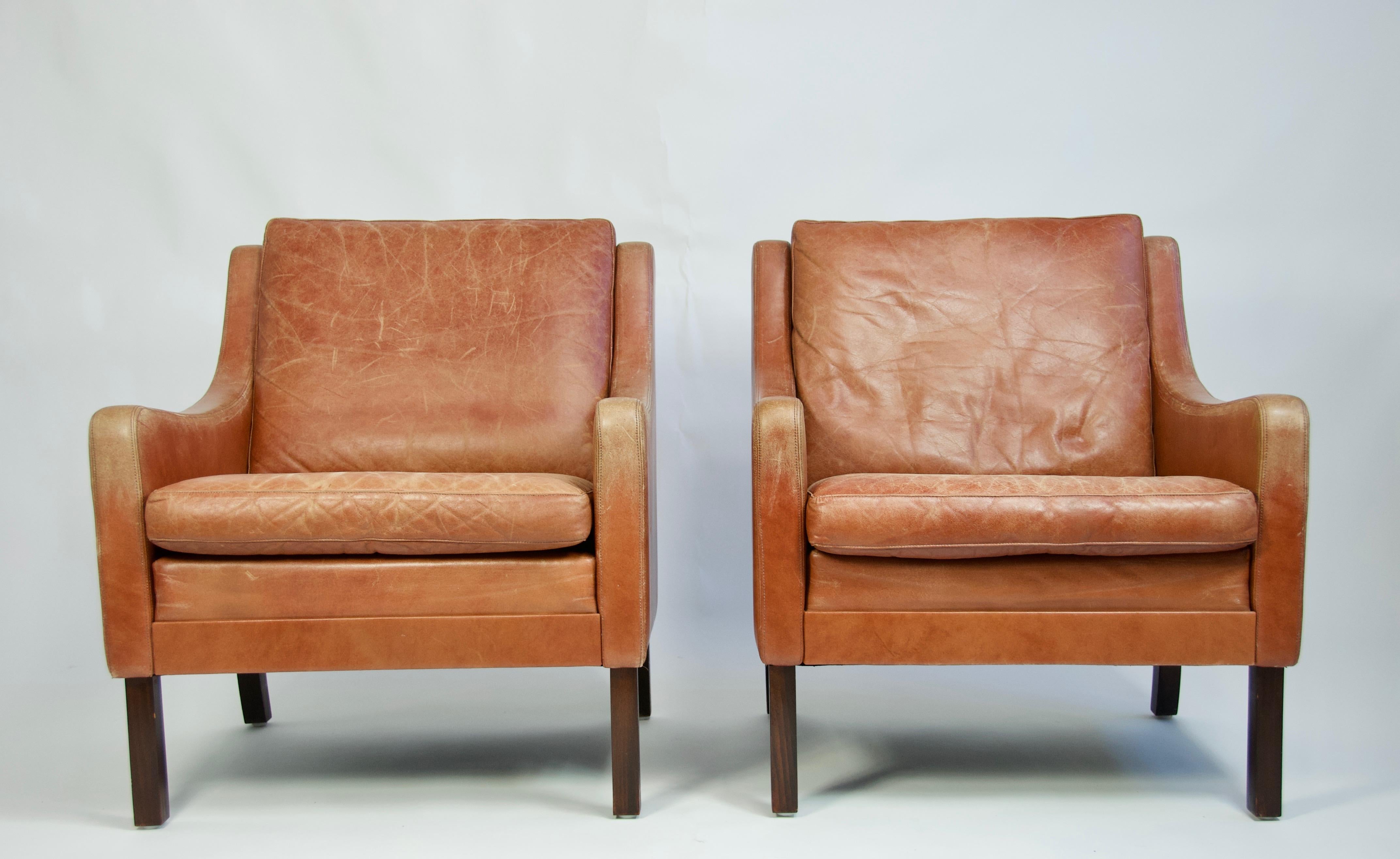 Pair of Danish lounge chairs with nicely worn original leather.