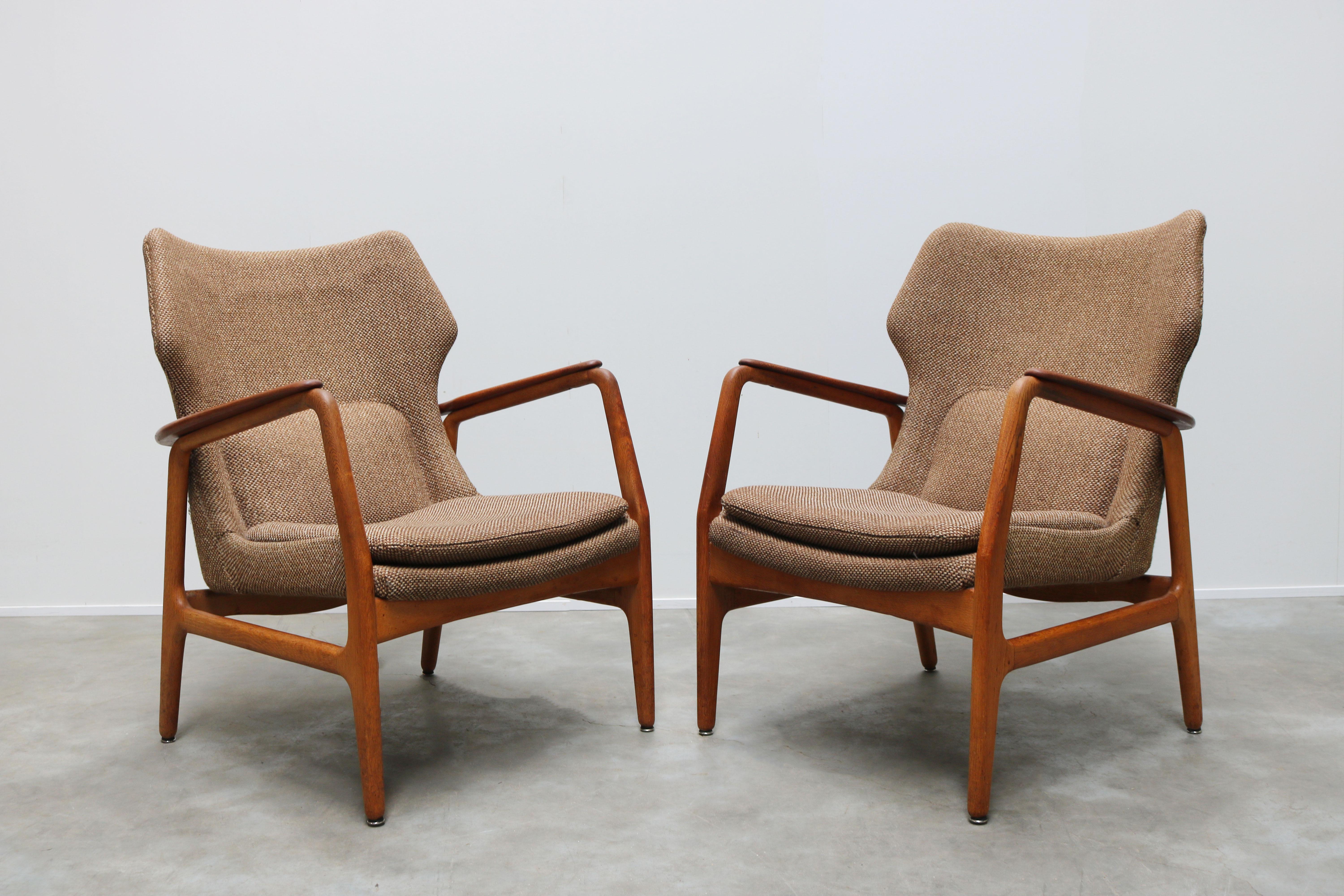 Magnificent pair of Danish ''wingback'' lounge chairs designed by the famous Danish designer: Aksel Bender Madsen for Bovenkamp furniture in the 1950s. The lounge chairs have a very royal and warm look, its smooth lines always draw your eyes towards