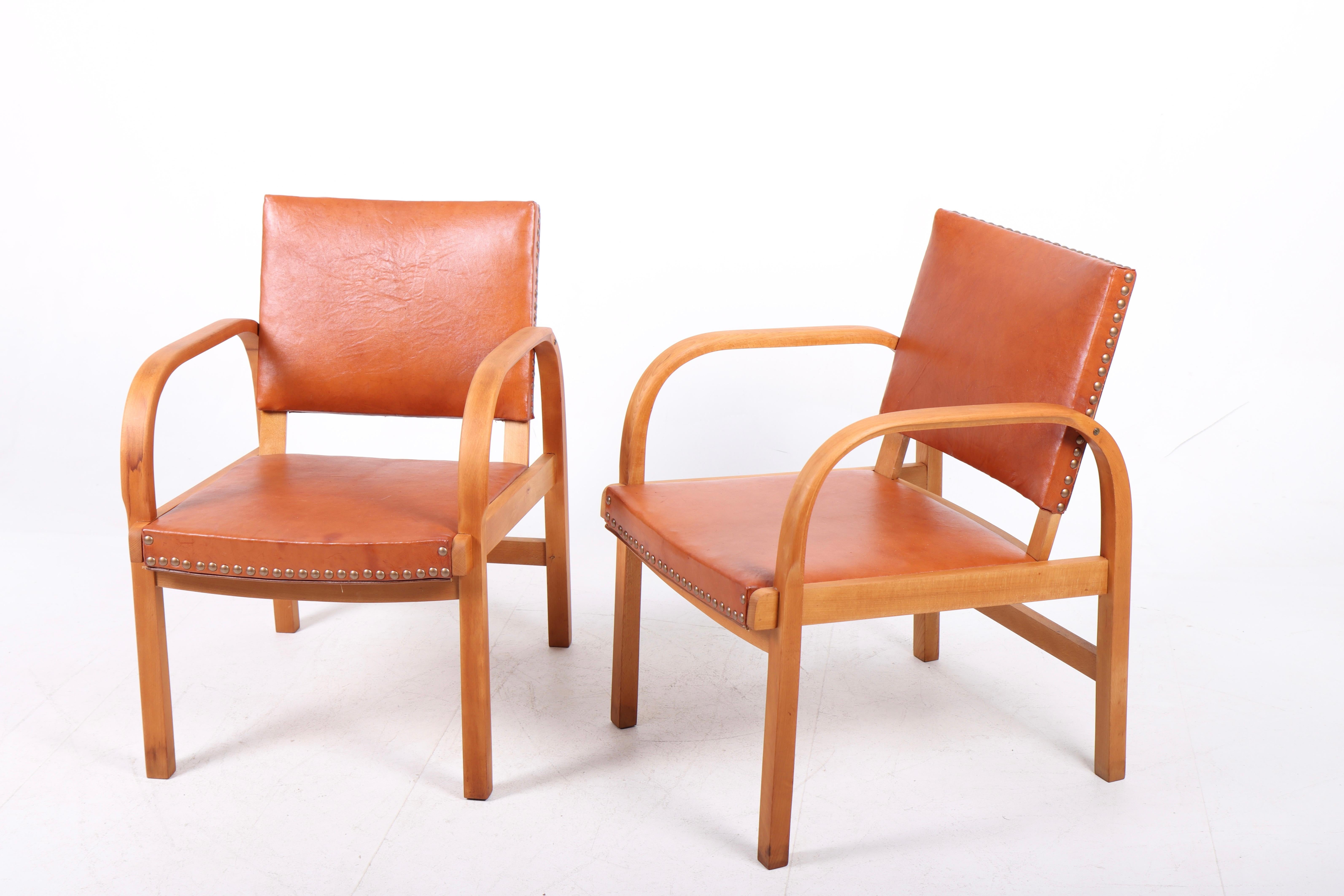 Pair of lounge chairs in beech and leather, designed by Magnus L. Stephensen and made by Danish cabinetmaker Fritz Hansen in the 1940s.