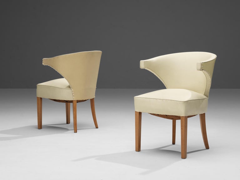 Pair of lounge chairs, beech, leatherette, Denmark, 1960s

Elegant Danish lounge chair with cream colored leatherette. The chair has a sculptural quality which is created by the armrests which have an interesting shape. The conical legs are made out