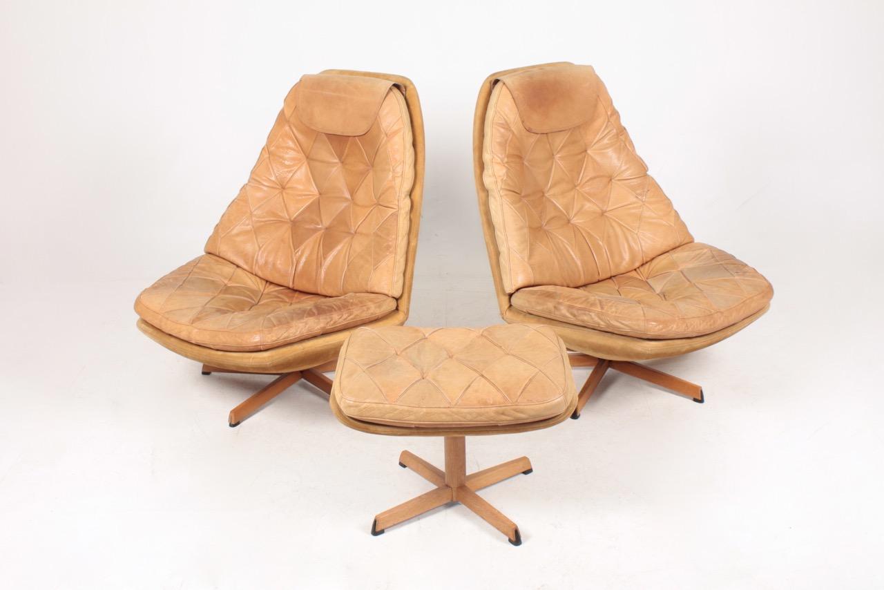 Pair of great looking and very comfortable swivel chairs with matching foot stools in beautifully patinated leather, designed by Danish architects Madsen & Schubell in the 1960s. Great original condition.