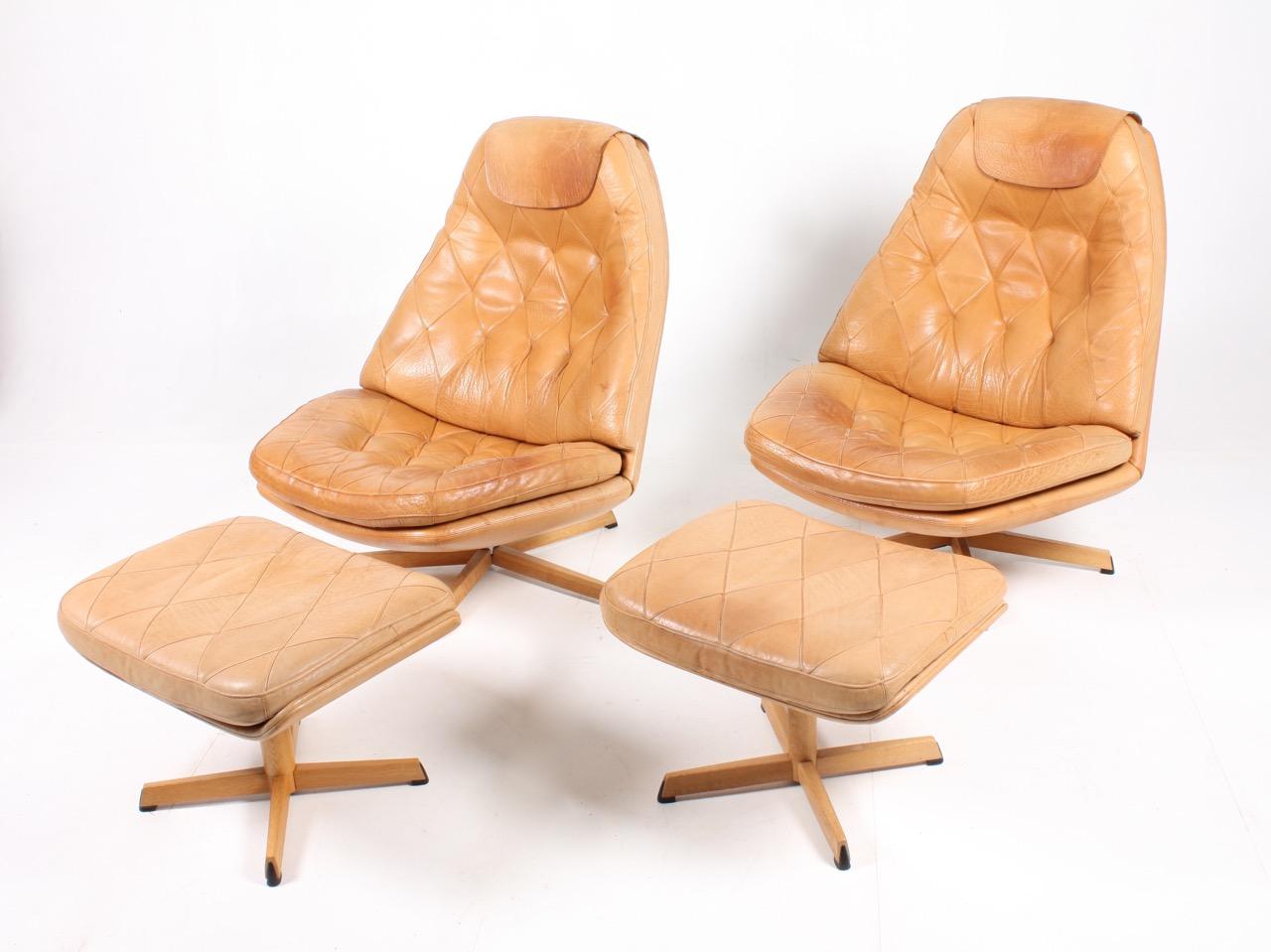 Pair of great looking and very comfortable swivel chairs with matching foot stools in beautifully patinated leather, designed by Danish architects Madsen & Schubell in the 1970s. Great original condition.