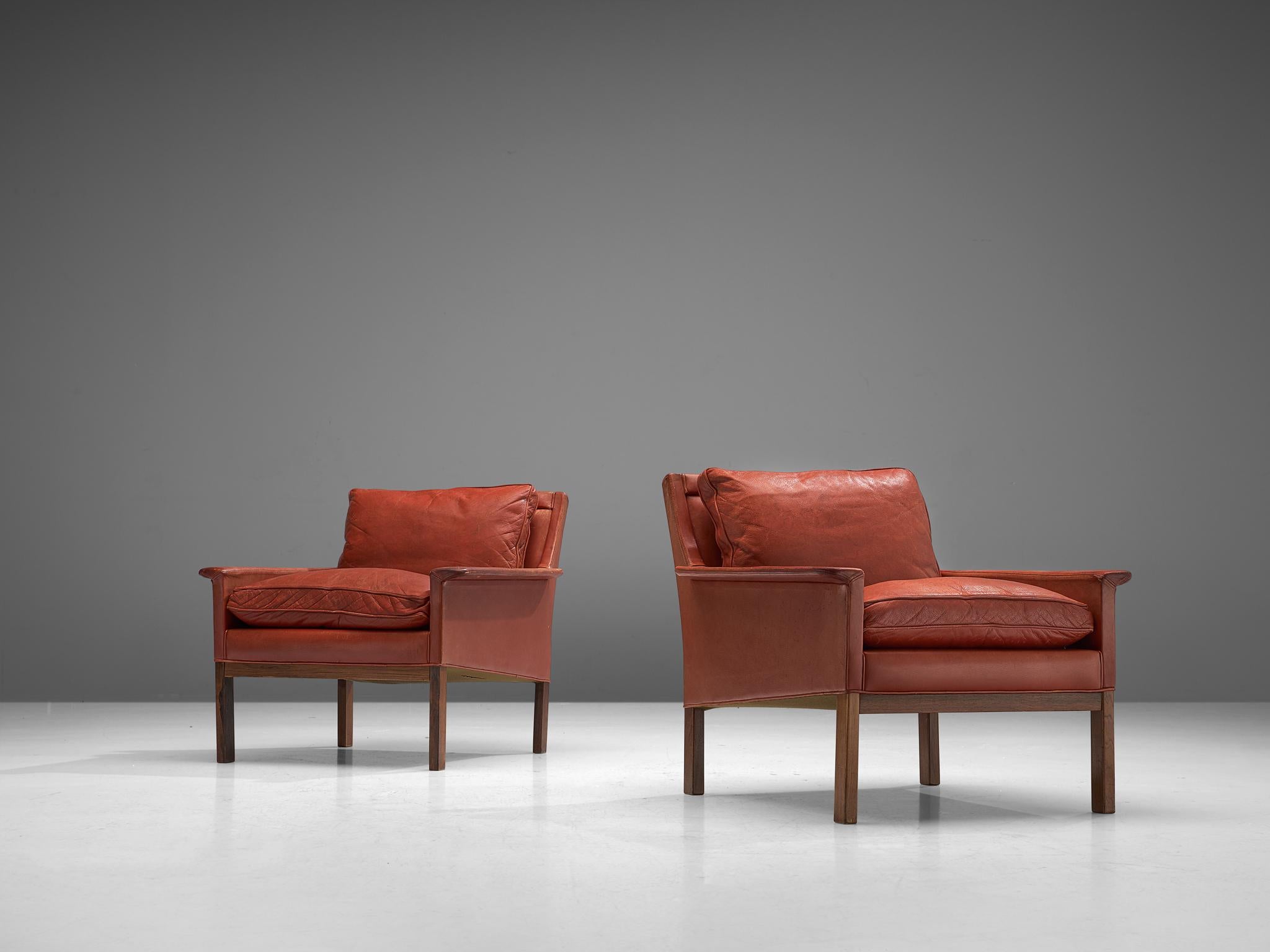 Pair of lounge chairs, red leather and darkened beech, Denmark, 1963.

Armchairs with an elegant design in the style Børge Mogensen. This set of lounge chairs have a low, tilted back, which is connected to the straight lined armrests which feature